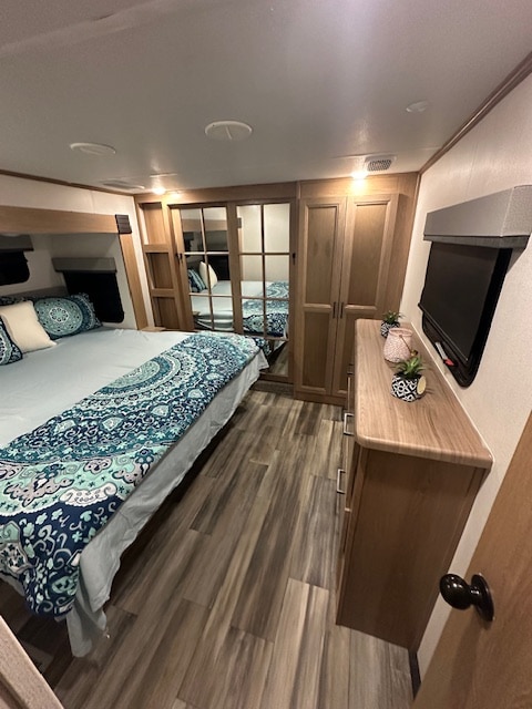 Comfortable RV rental bedroom featuring a queen bed, dresser, TV, & mirrored closet doors. Great for travel!. Primetime Sanibel 2023