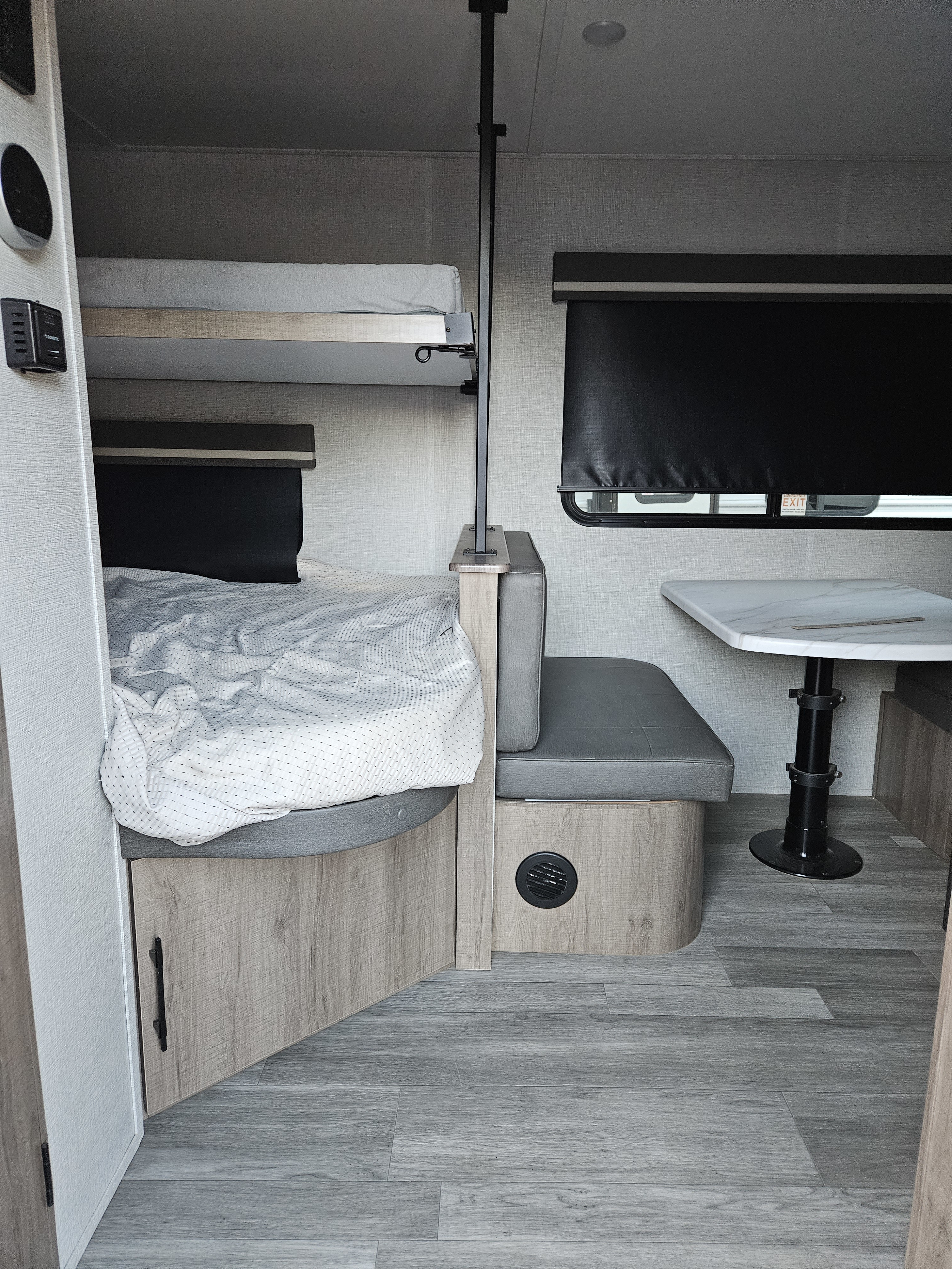 Cozy RV rental interior: bunk beds, dinette, and Dometic controls visible. Compact living on the road for your next trip.. Grand Design 2023