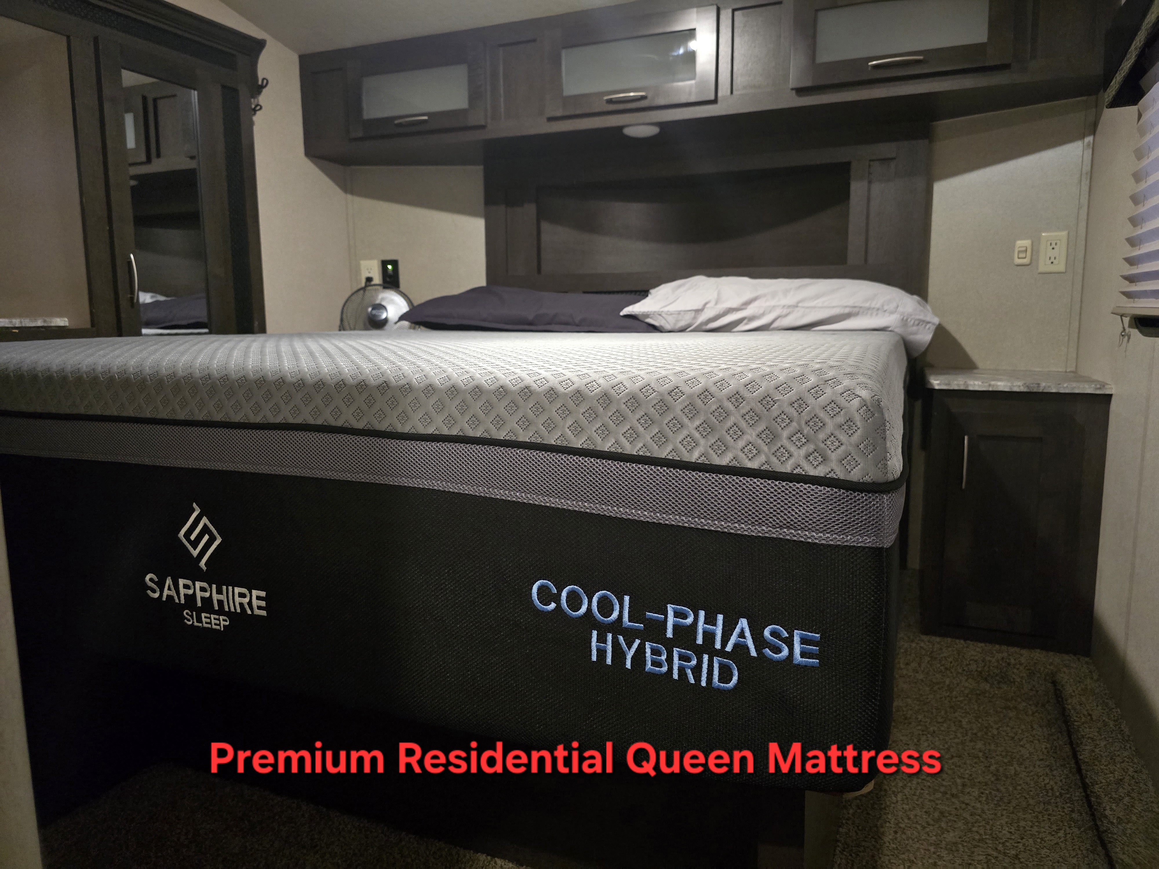 Premium residential queen mattress in an RV rental bedroom. Enjoy cool, hybrid sleep in your camper.. Forest River Shockwave 2018