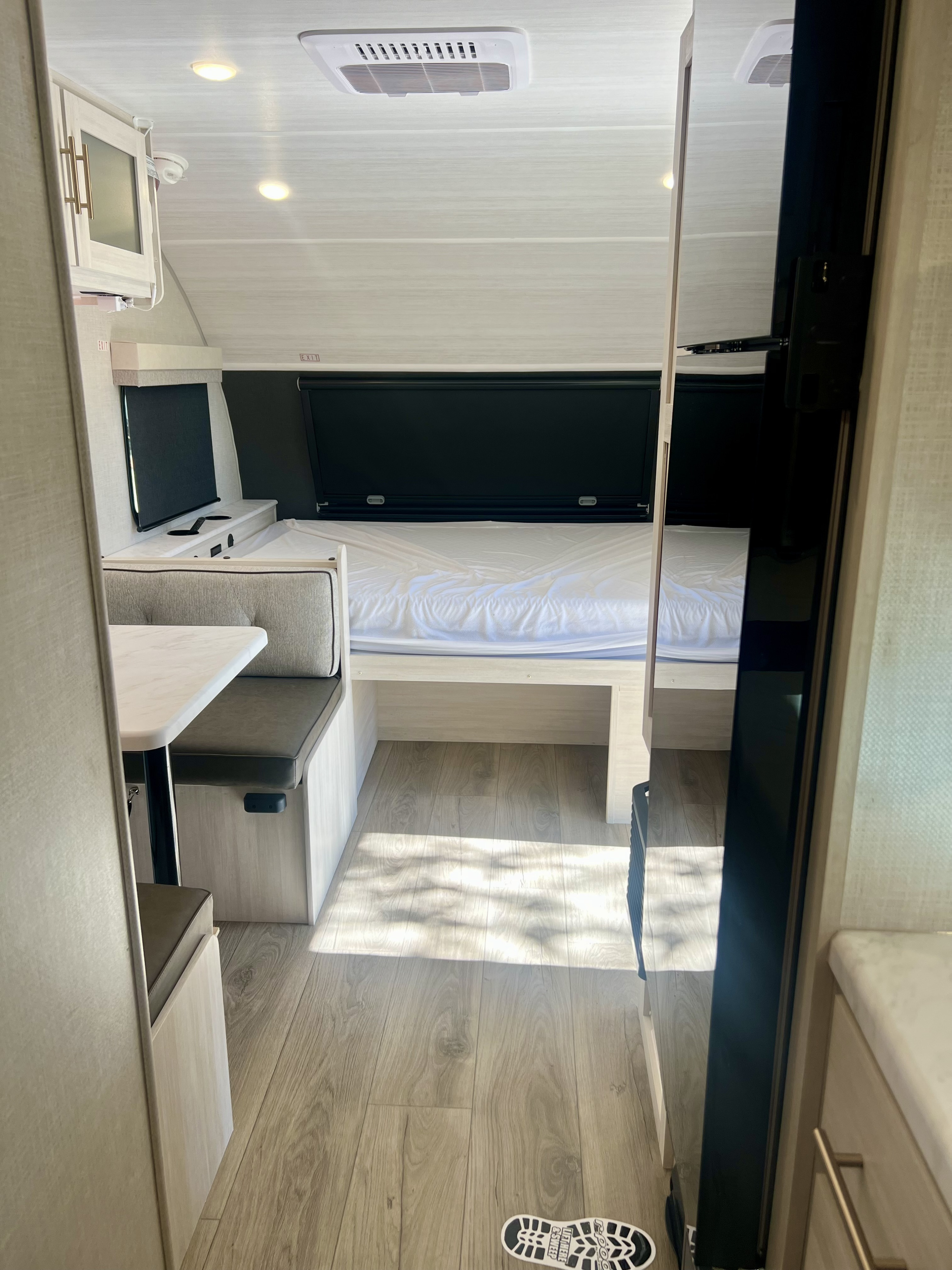 RV rental interior with a comfy bed, dinette, and bright lighting, perfect for travel adventures.. Forest River R Pod 2026