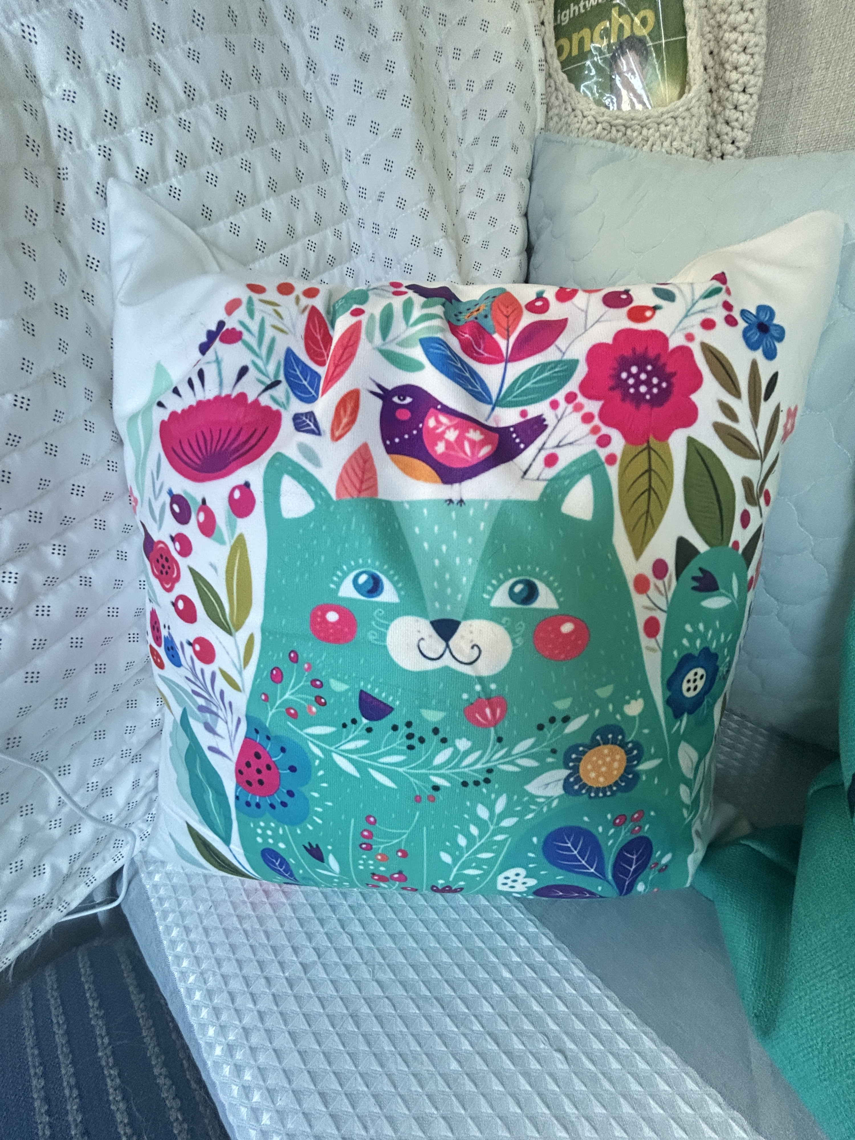 Cheerful cat & floral pillow brightens this cozy RV rental space, nestled on quilted and plush bedding.. Thor Motor Coach Freedom Elite 2026