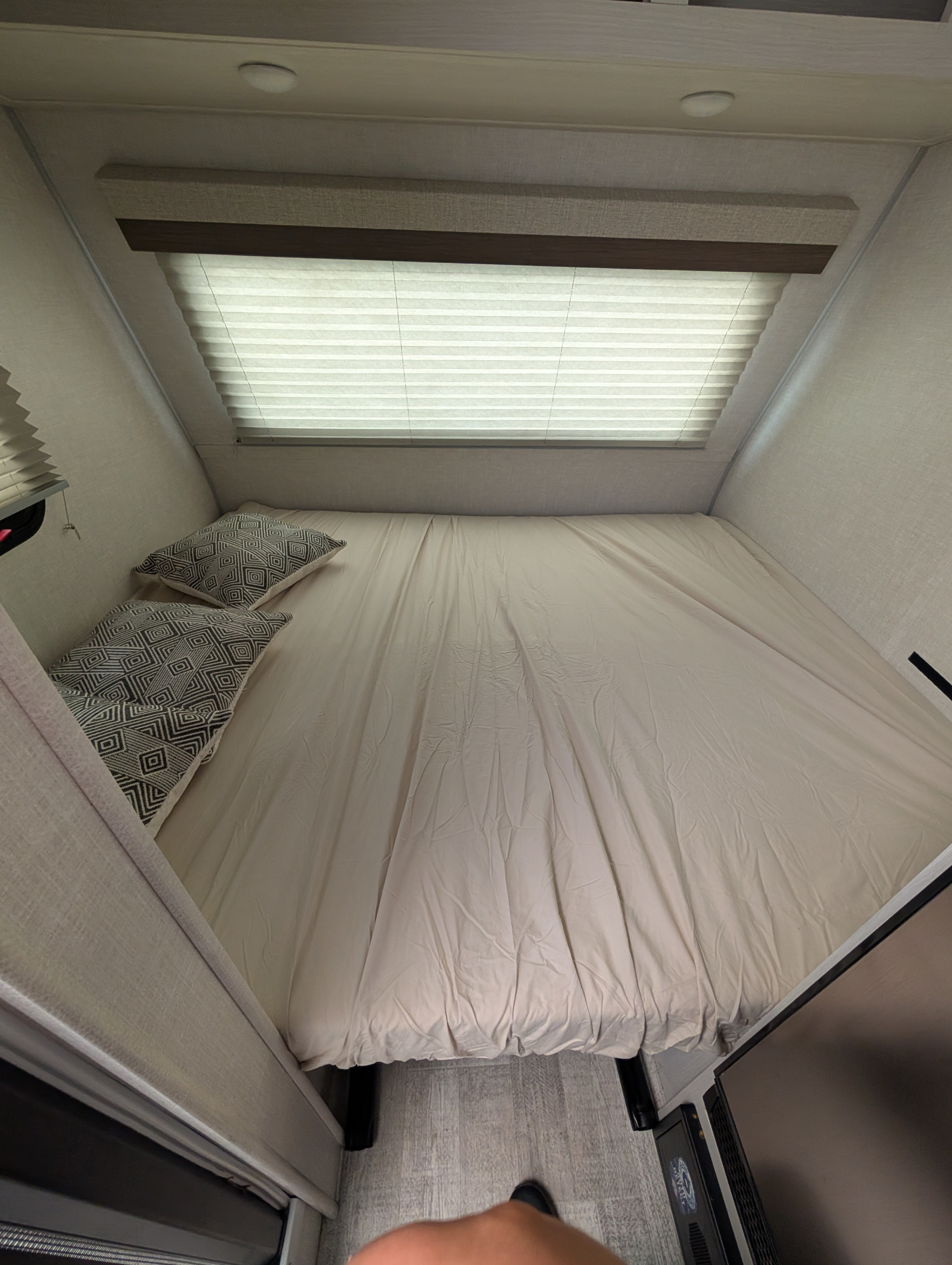 RV rental bedroom: a cozy compact bed with patterned pillows, window blinds, and recessed lighting.. No Boundaries 16 2024