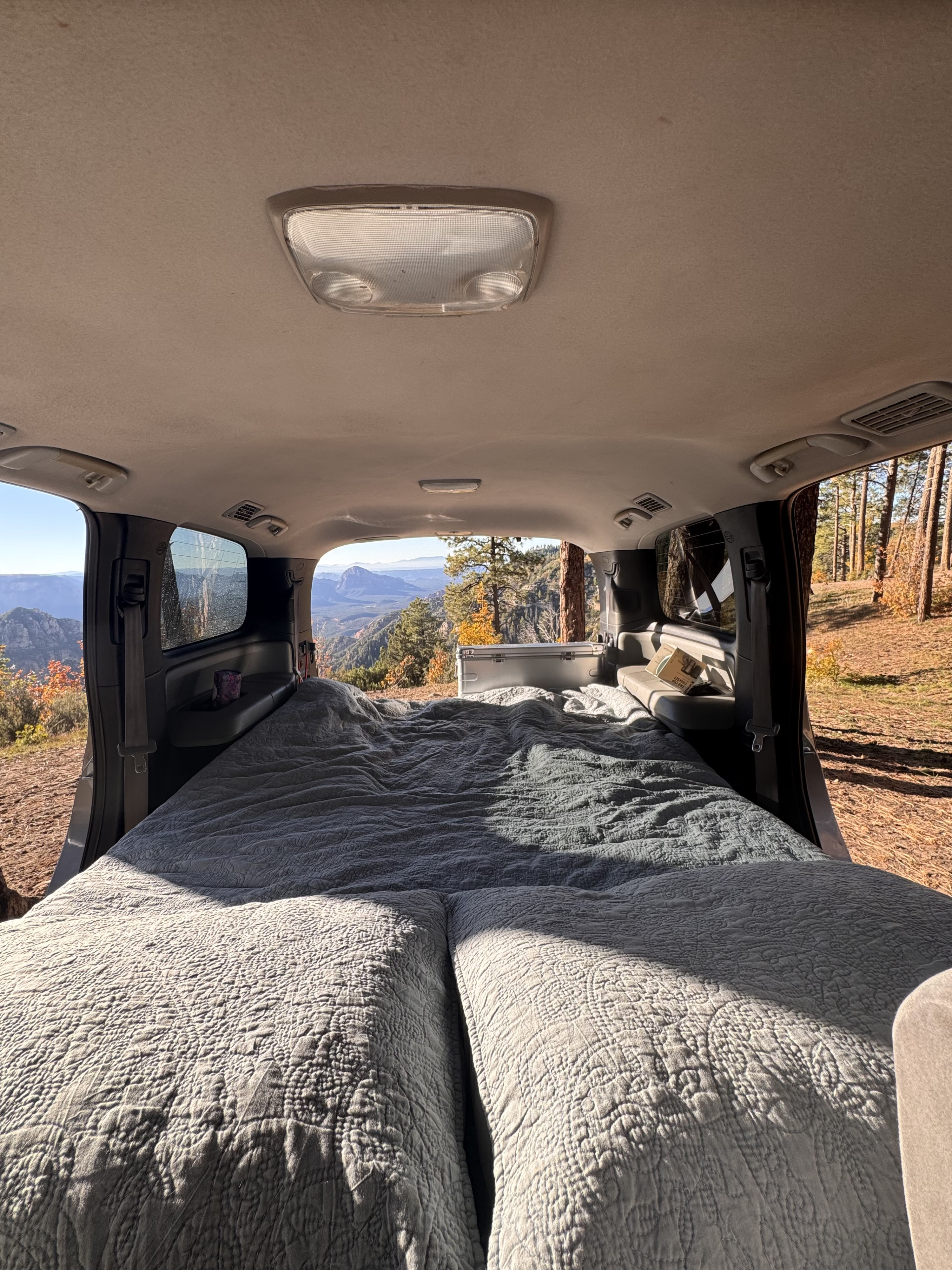 Cozy converted van bed overlooking stunning mountain scenery, perfect for an RV rental adventure.. Toyota Dreamseeker Voyager 2008