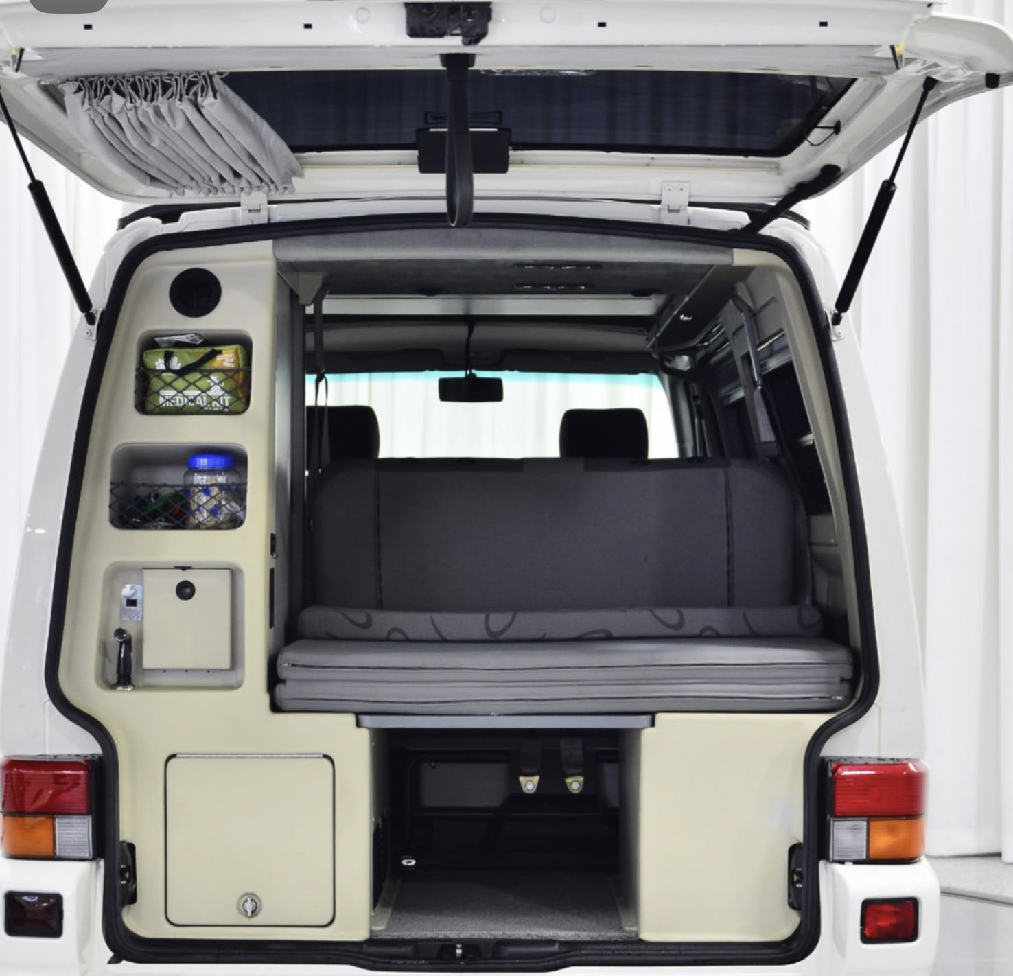 RV rental: Camper van's open rear reveals a fold-down bed, integrated storage, and sink unit for mobile living.. Volkswagen Multivan 2001