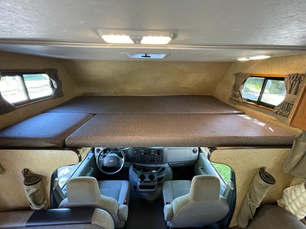 RV rental interior: A wide-angle view shows the roomy cab-over bunk bed above the dashboard and driver/passenger seats.. Other Other 2016