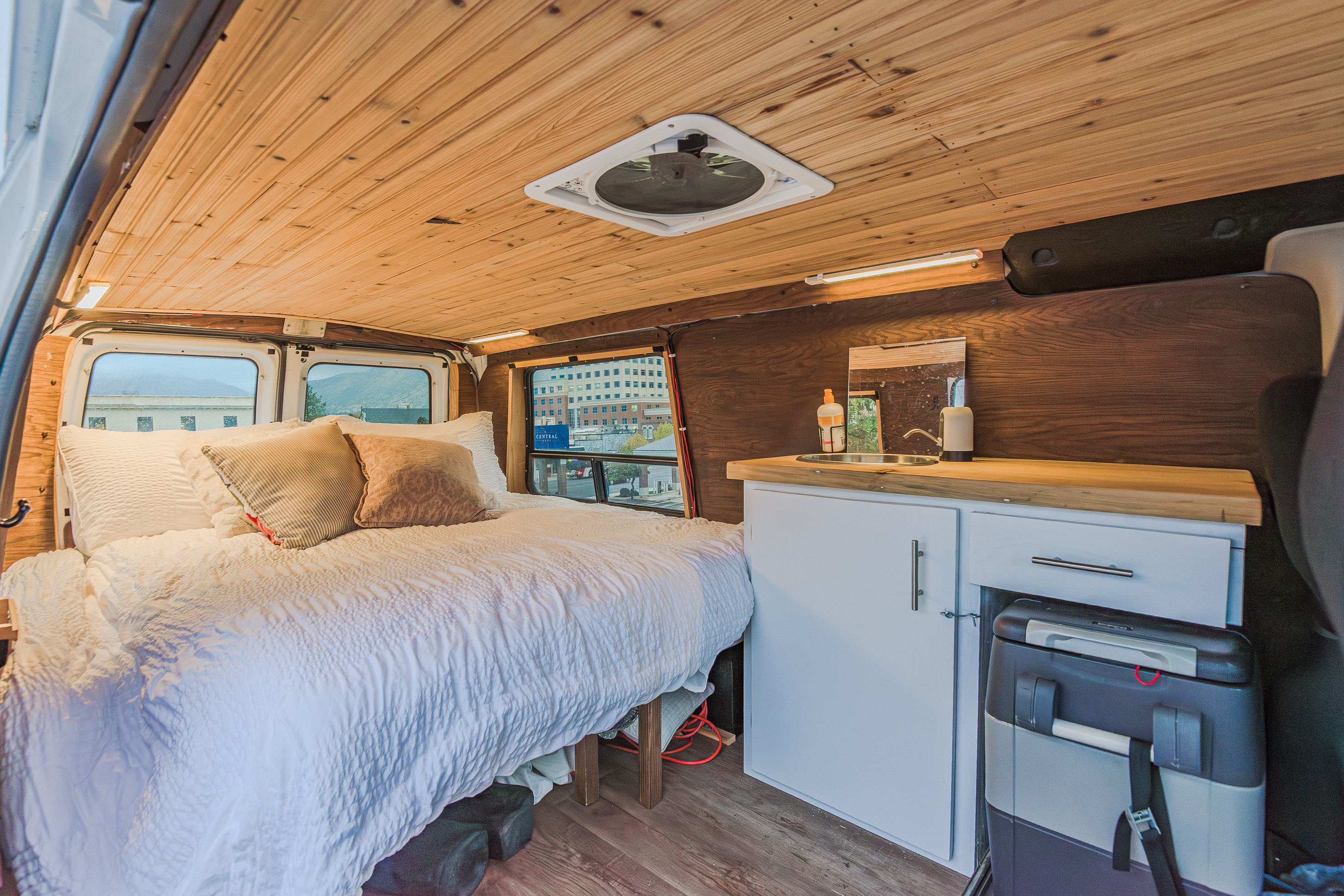 This cozy rv rental camper van interior has a comfy bed, mini kitchen with sink, wood-paneled ceiling & walls.. Ford Econoline E250supercab 2008