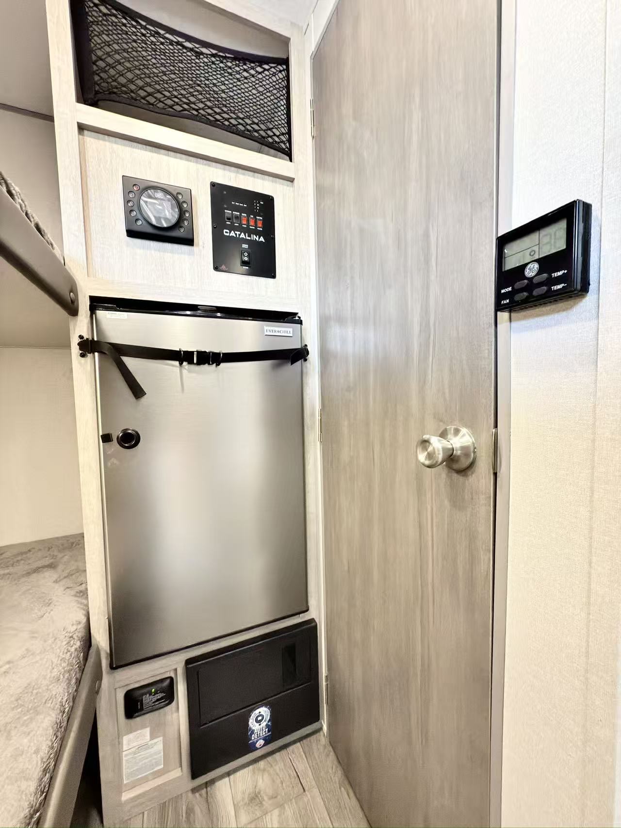 RV rental interior: Everchill fridge, JBL audio, Catalina controls, GE thermostat, fuse box, and bunk beds for comfortable travel.. Coachmen Catalina Summit 7 134BHX 2025
