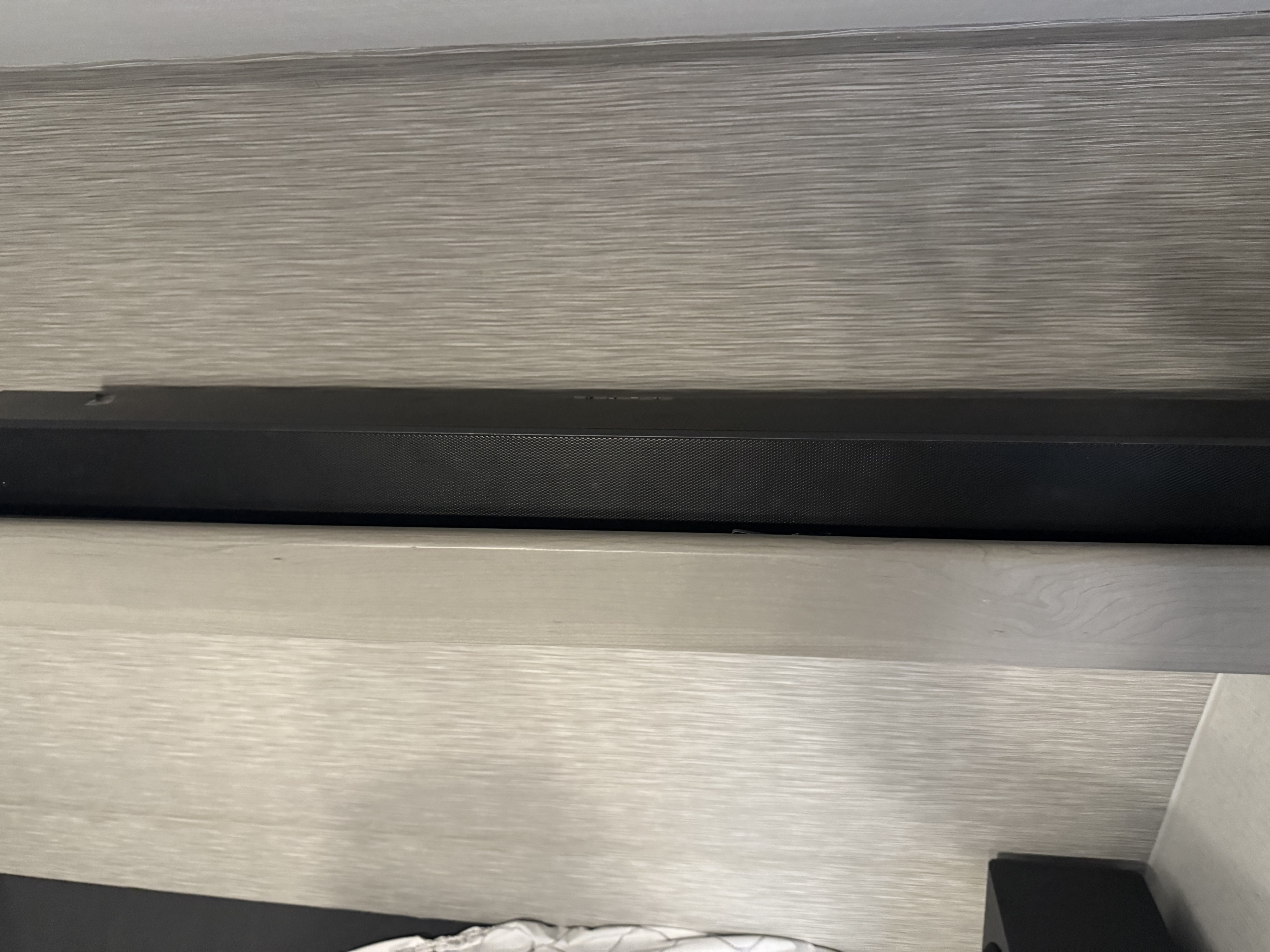 In an RV rental, a black soundbar is integrated into the entertainment area, nestled between textured wood-grain panels.. Keystone RV Hideout Sport 2025