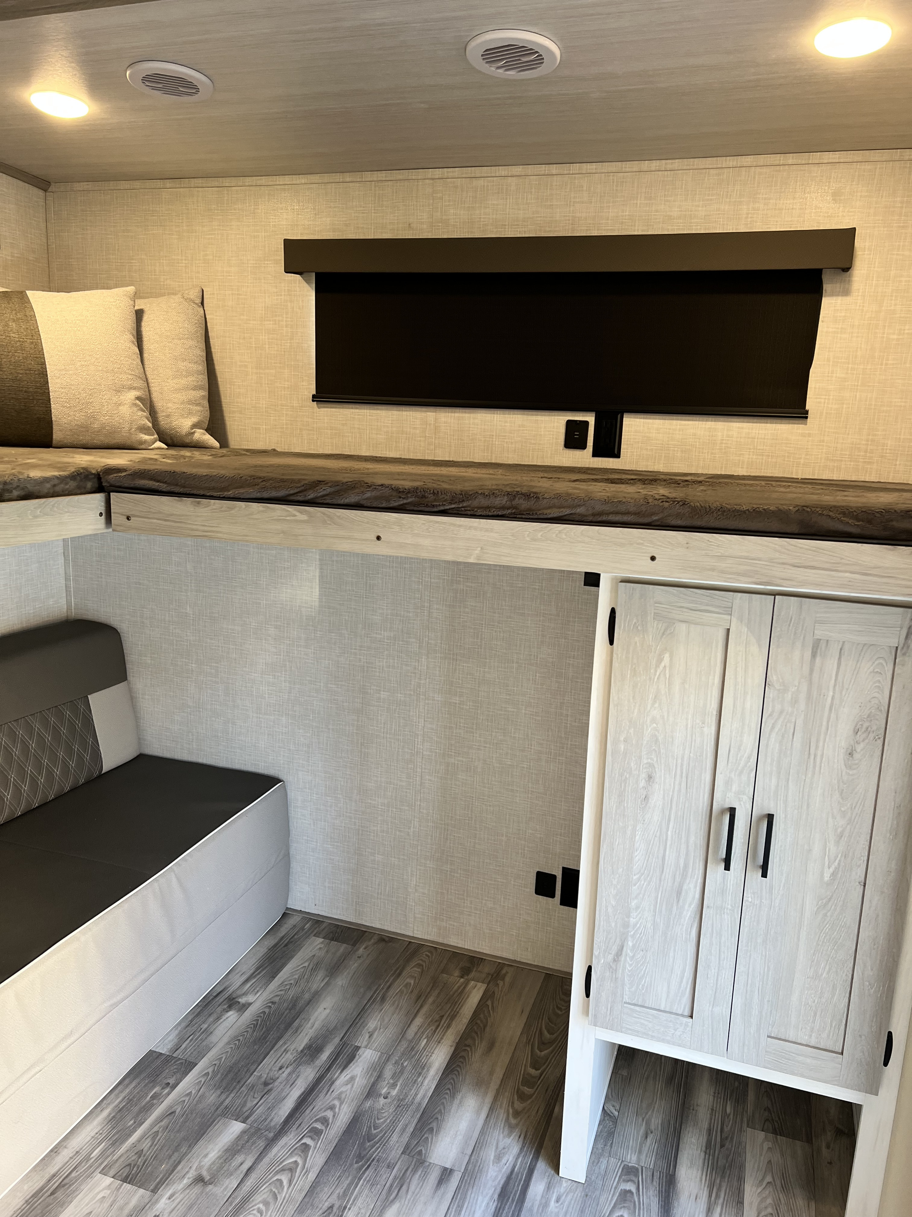 Step inside this modern RV rental: a cozy bunk bed area with a storage cabinet, window blind, and ceiling lights.. Forest River Impression 2021