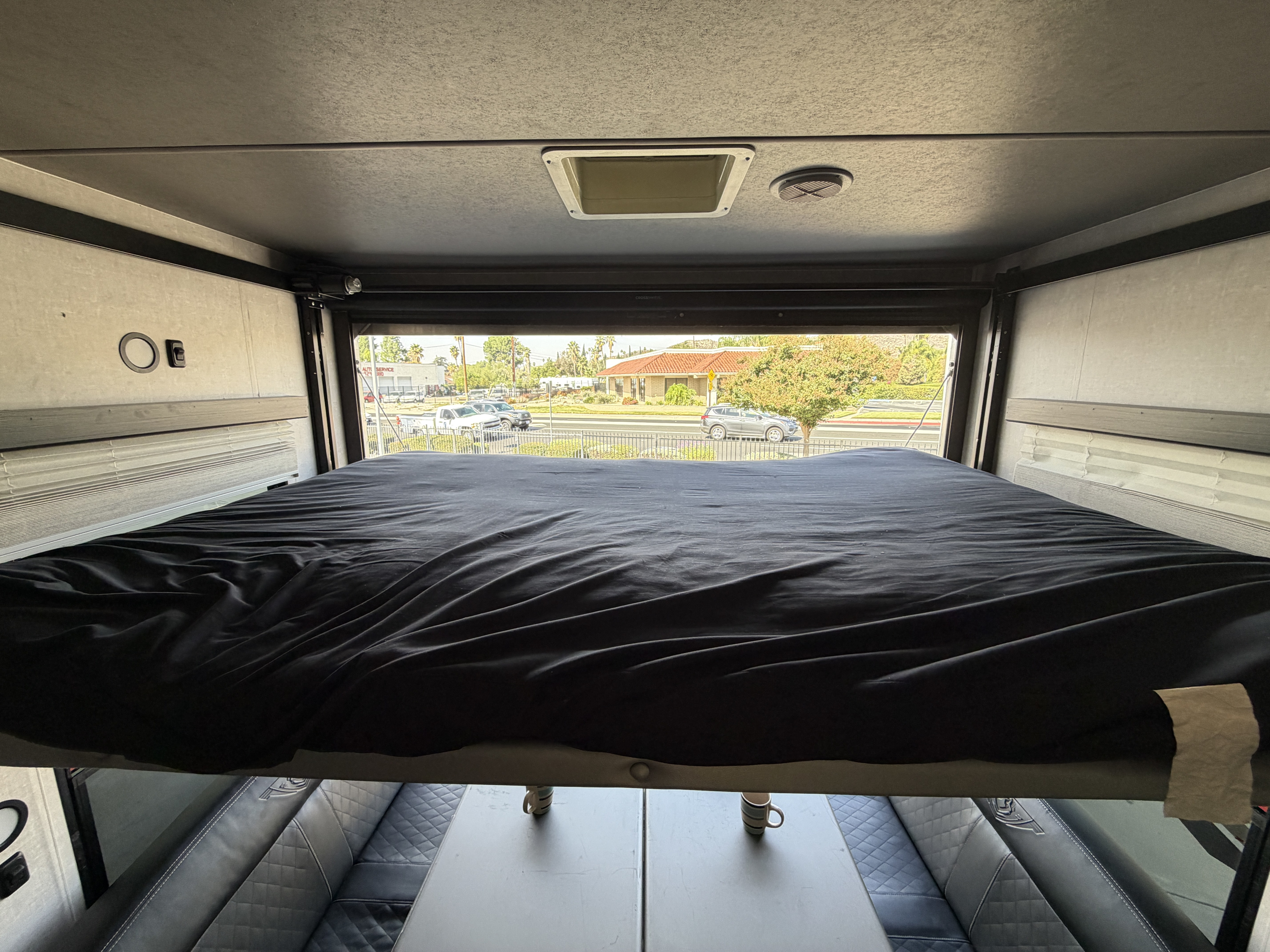 Experience this RV rental's elevated bed, flexible living space with table and seating below, plus a scenic outside view.. Eclipse Stellar Pro Lite Toy Hauler 2020
