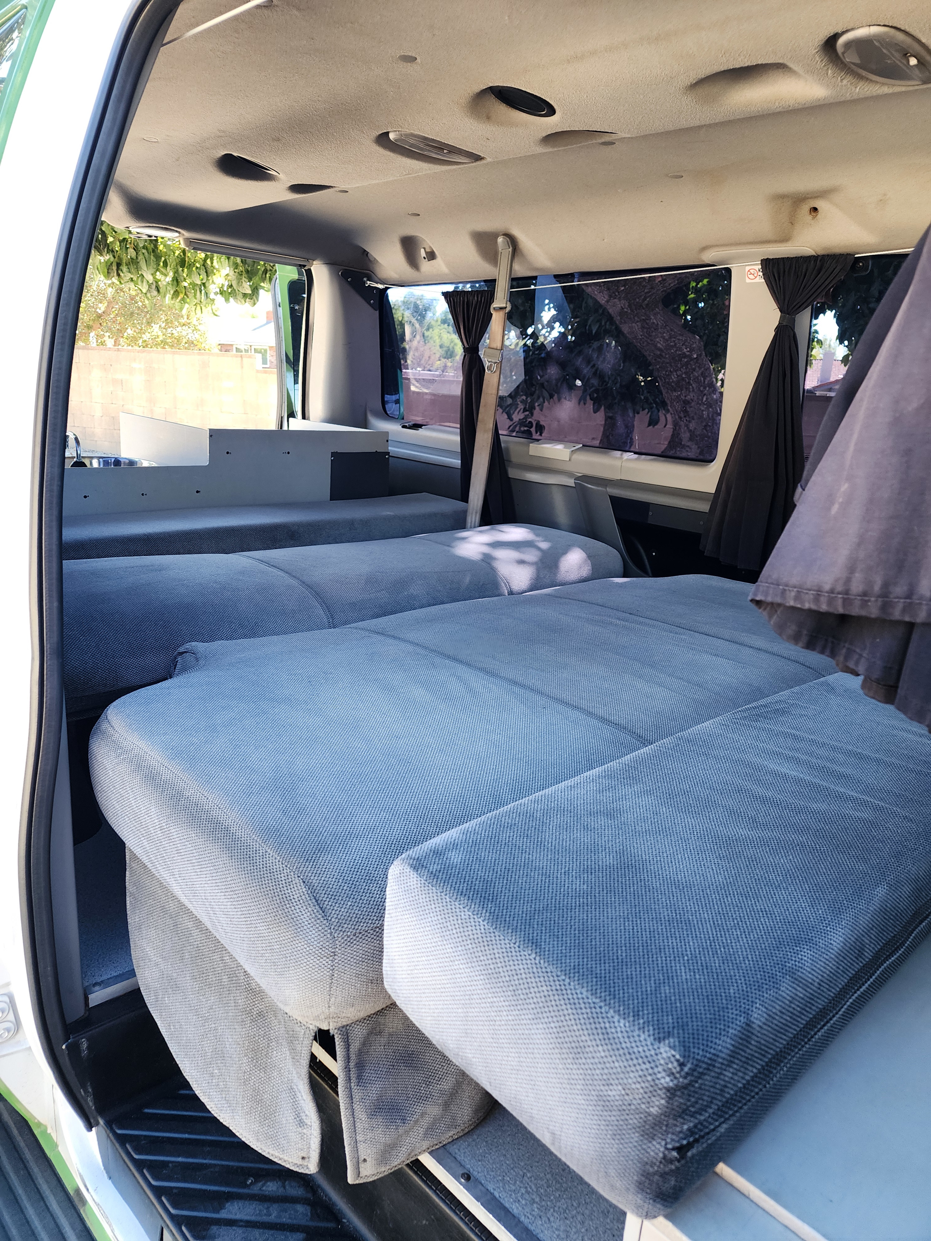 RV rental interior: a flexible camper van with modular blue beds, a compact sink, and overhead lighting for mobile living.. Escape Trailer Industries E150 XLT 2011