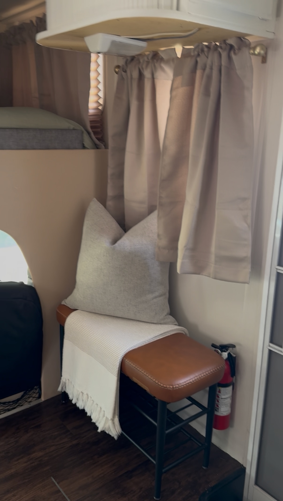 This cozy RV rental interior features a bunk bed, cushioned bench with a throw, curtains, and a visible fire extinguisher.. Ford Jayco Eagle 2001