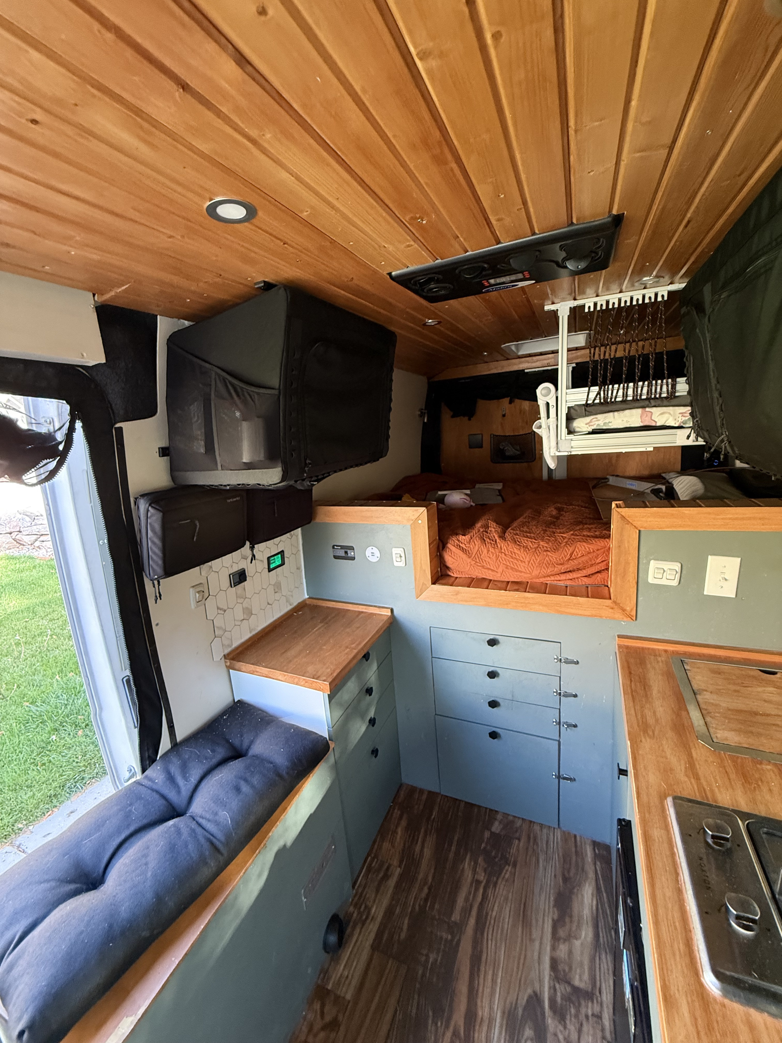 RV rental: Cozy campervan interior with wood ceilings, compact kitchen, comfy bed, and smart storage for your next adventure.. Other Other 2018