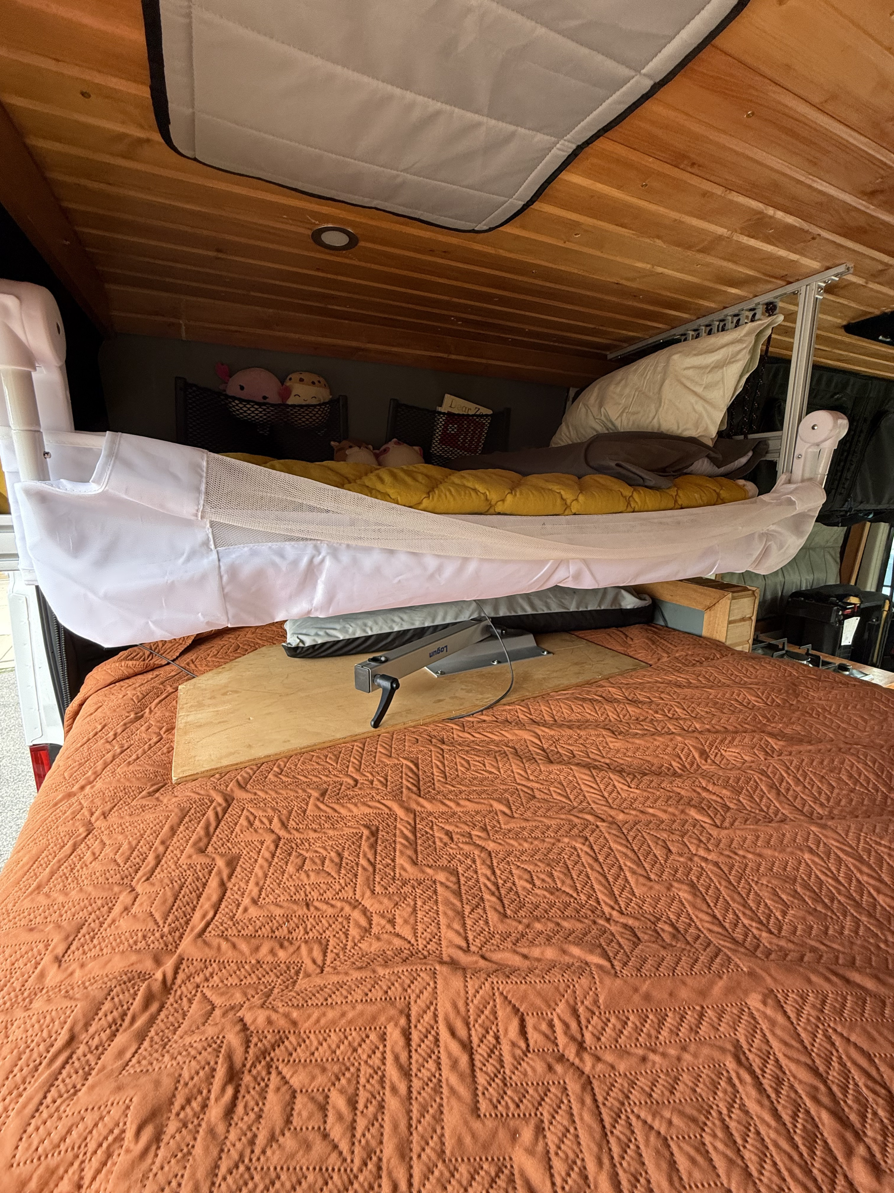 Inside an RV rental, a baby bassinet is suspended above the main bed, providing extra sleeping space for family adventures.. Other Other 2018