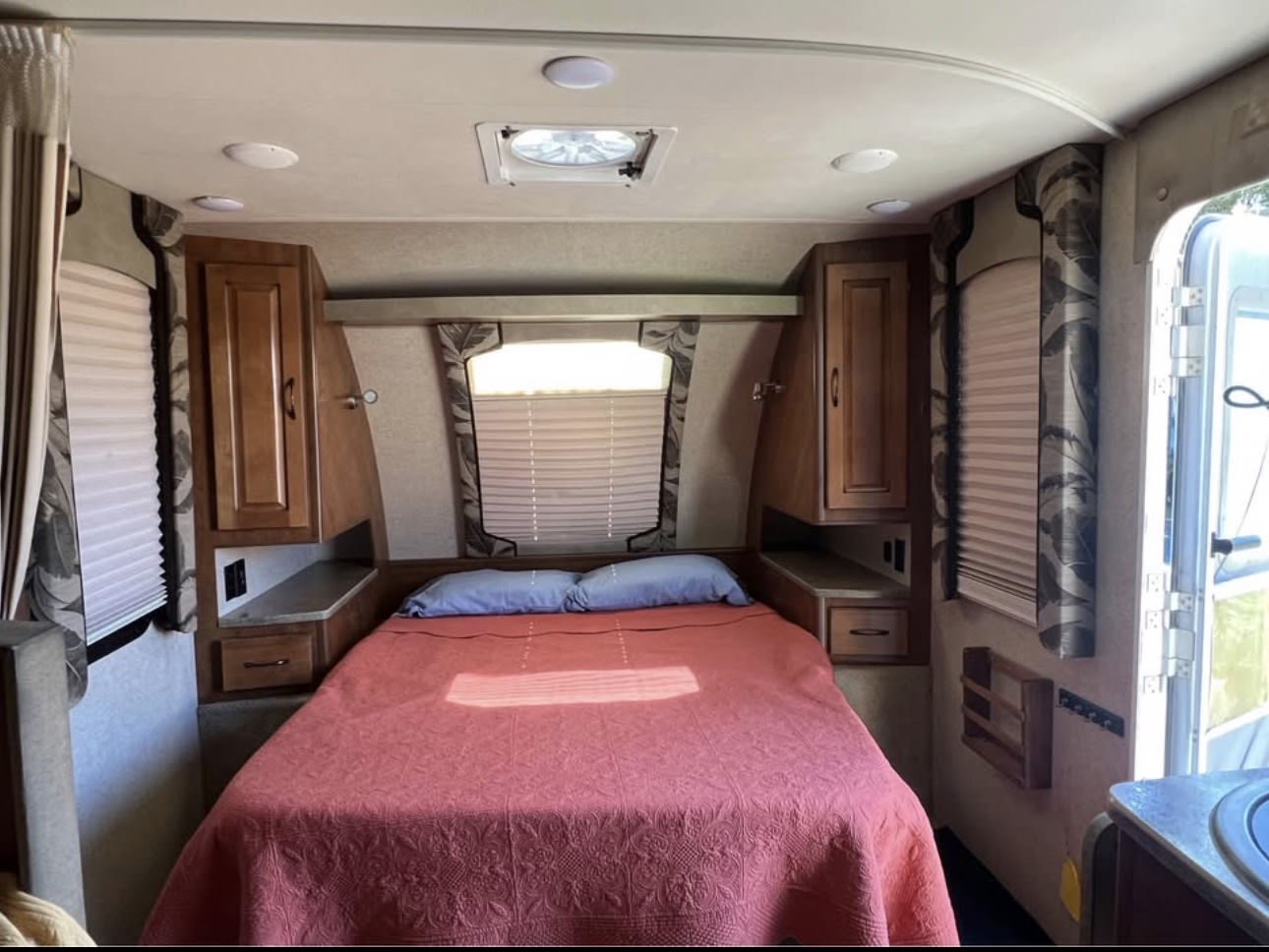 Cozy rv rental bedroom featuring a comfy bed, integrated storage, side shelves, and window blinds for your next adventure.. Lance Manufacturing Lance Manufacturing Trailer 2016