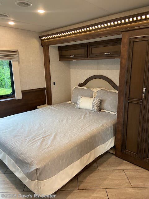 Relax in this cozy RV rental bedroom, featuring a comfortable bed, overhead cabinets, and ambient lighting for your travels.. Bay Star Bay Star Motorhome 2022