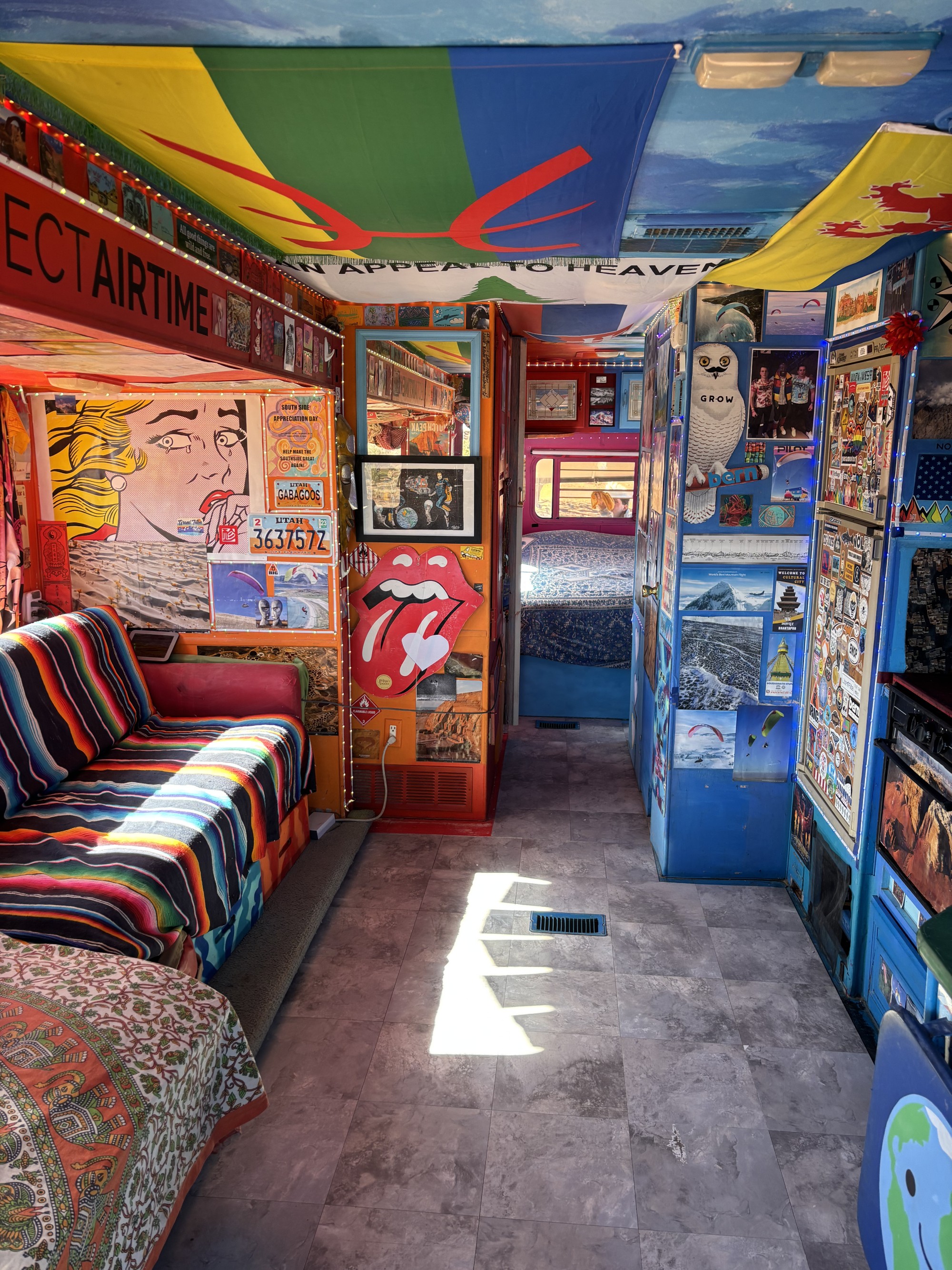 Vibrant, eclectic RV rental interior with colorful decor and a cozy living space, perfect for unique travel adventures.. Warn The West TumbleWeed 2026