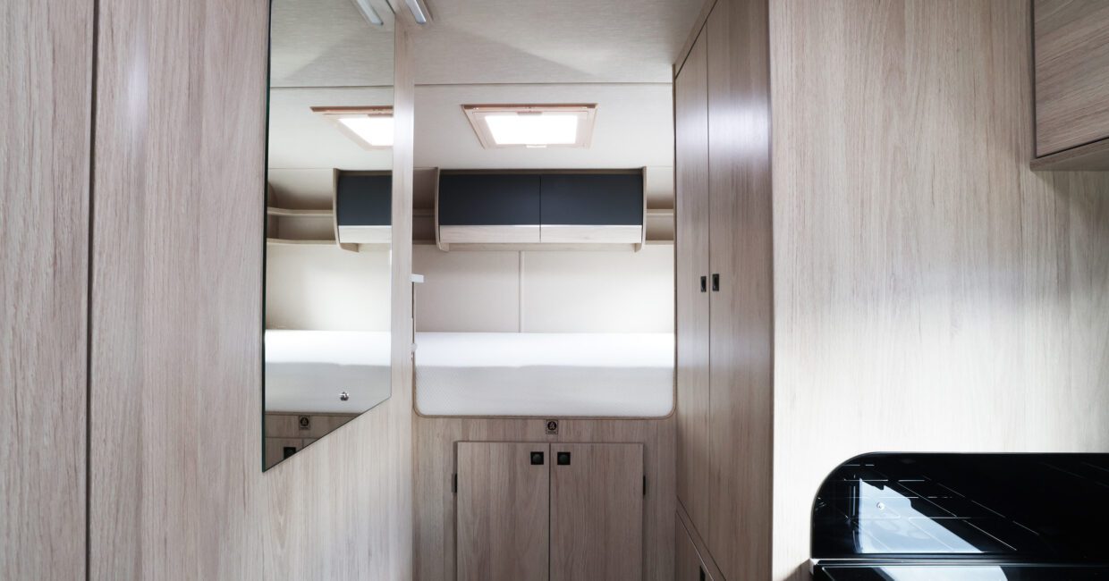 Modern rv rental interior: compact camper bedroom with light wood paneling, a comfy bed, skylight & storage.. Auto Trail Expedition C73 - 2026 2026