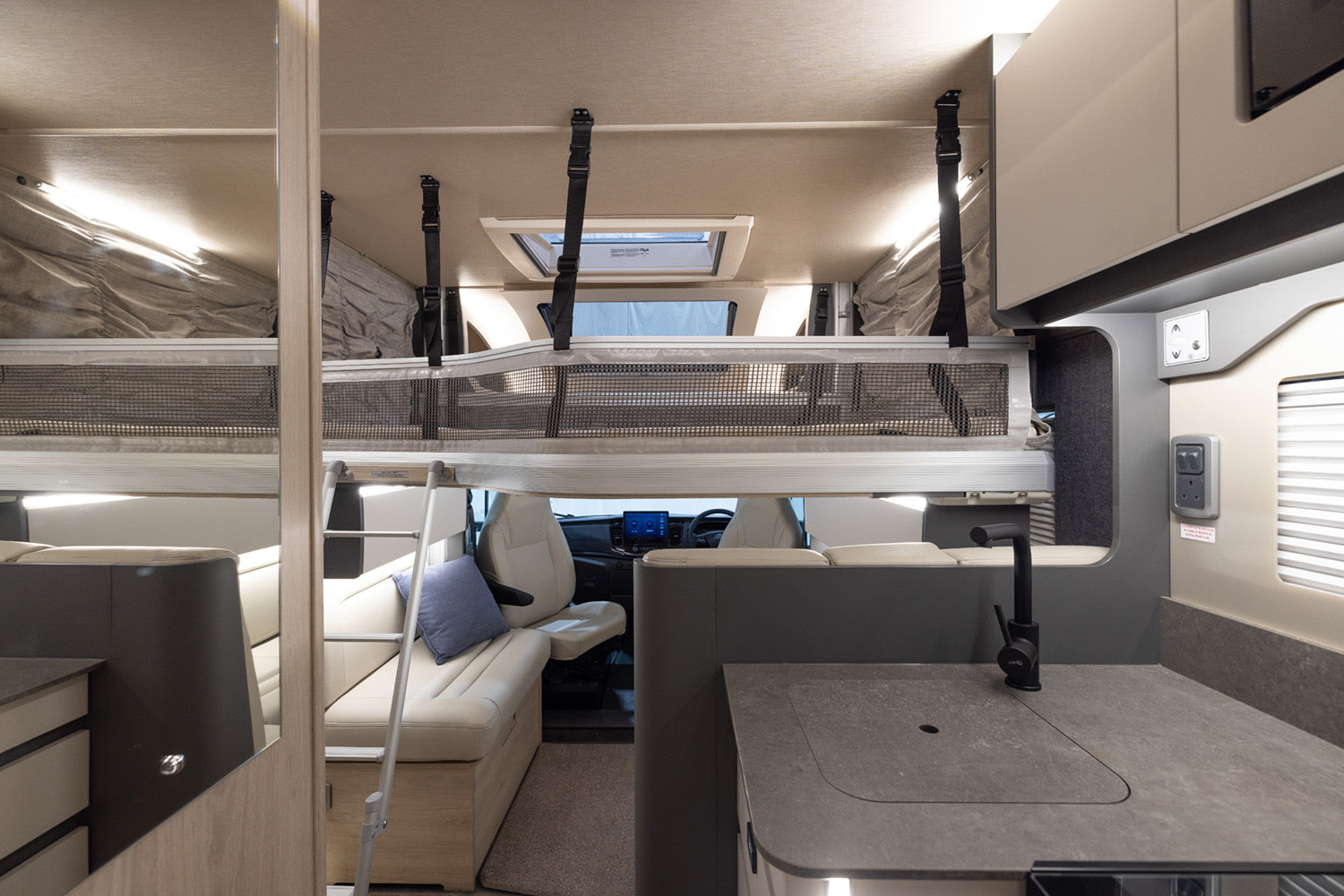 Spacious RV rental interior featuring an overhead bunk bed, living area, and modern kitchen counter. Perfect for family adventures.. Auto Trail F 70 2026