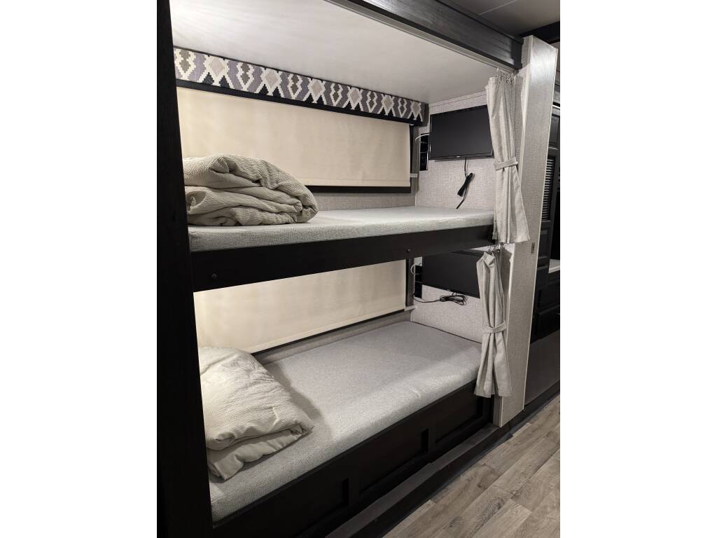 Comfy bunk beds in your RV rental, each with a TV & privacy curtain for a personalized sleep space.. Entegra Coach Vision XL 2021
