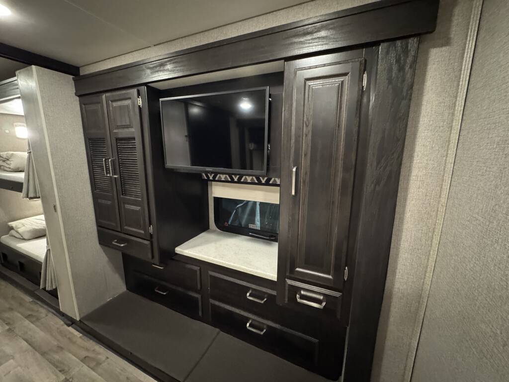Spacious RV rental interior with bunk beds, an entertainment center, and built-in storage for a comfortable trip.. Entegra Coach Vision XL 2021