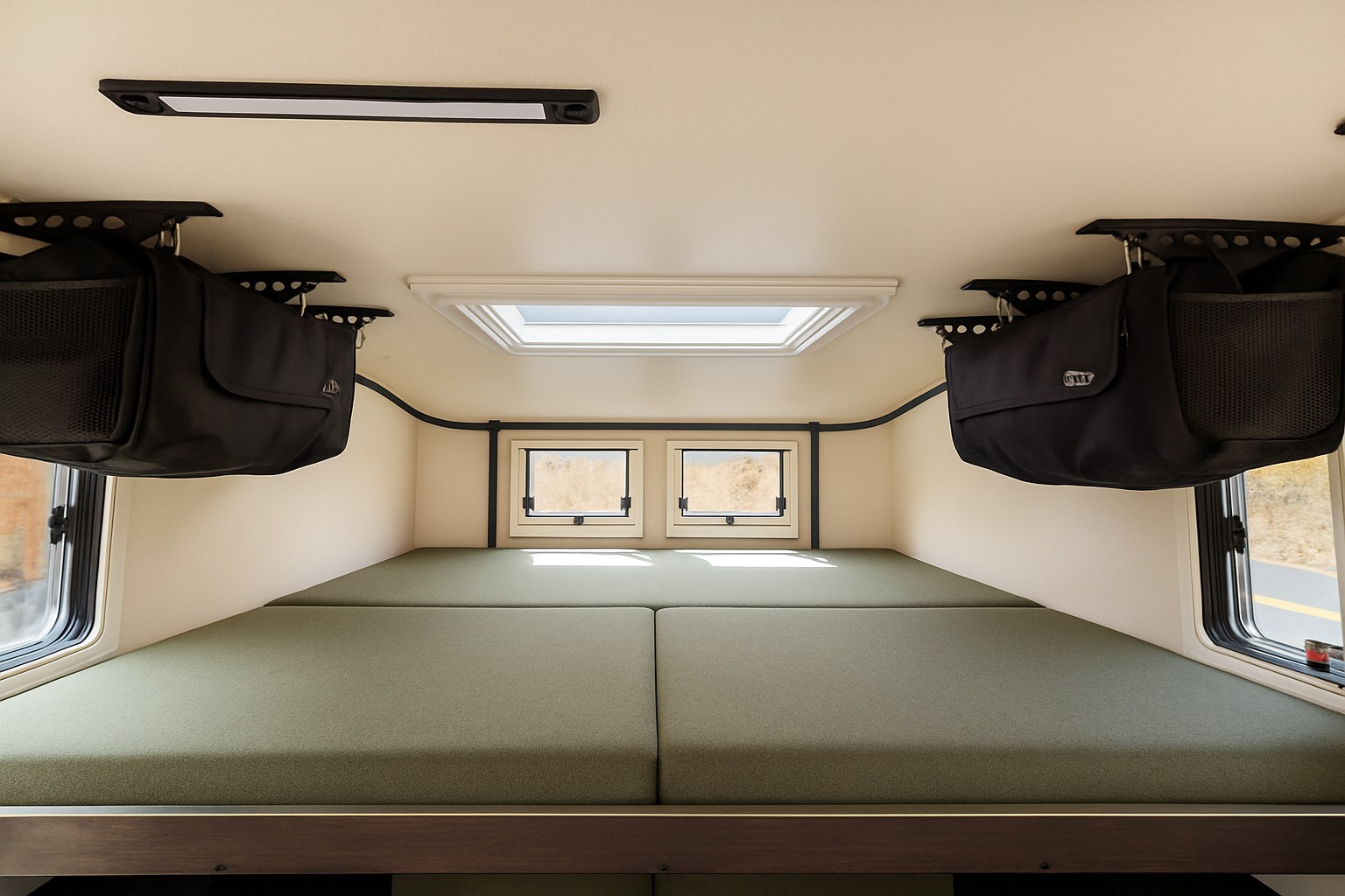 RV rental interior: Comfortable sleeping area with green bed, windows, skylight, and hanging storage for organized travel.. SCOUT KENAI 2025