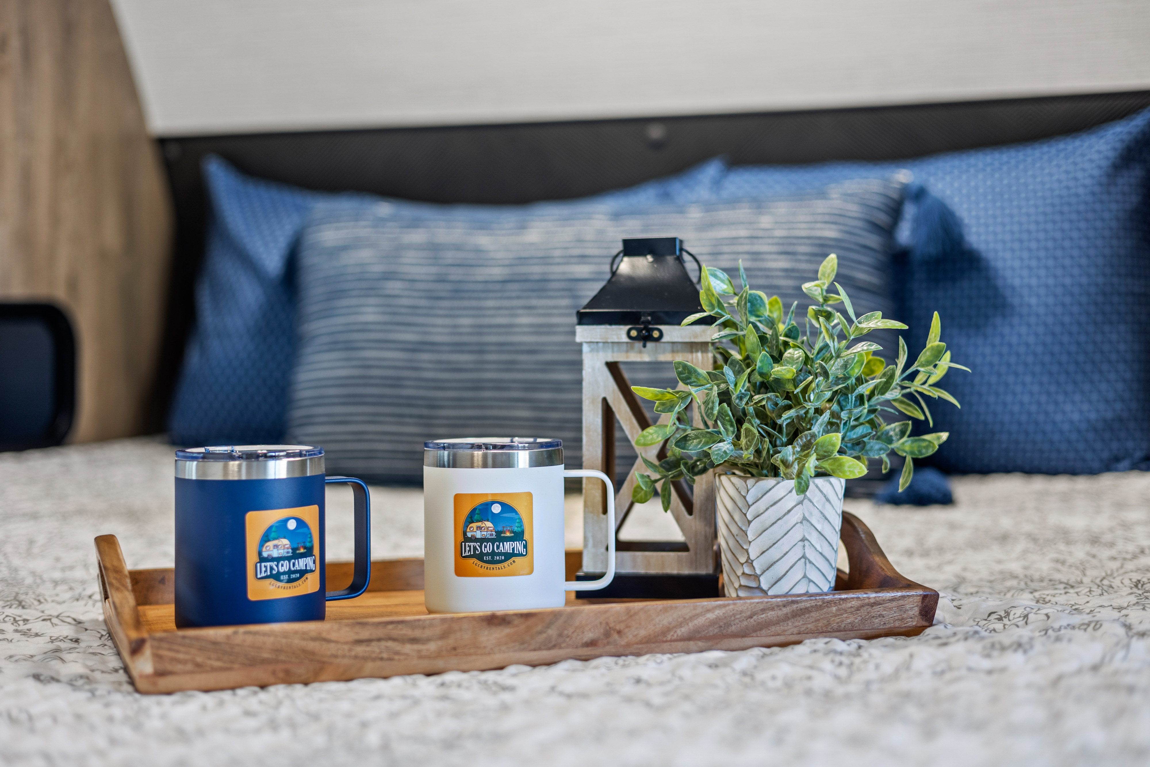 Cozy RV rental decor: "Let's Go Camping" mugs, a lantern, and plant on a tray, perfect for your LGCRYRENTALS.COM adventure.. Heartland RVs Pioneer 2021