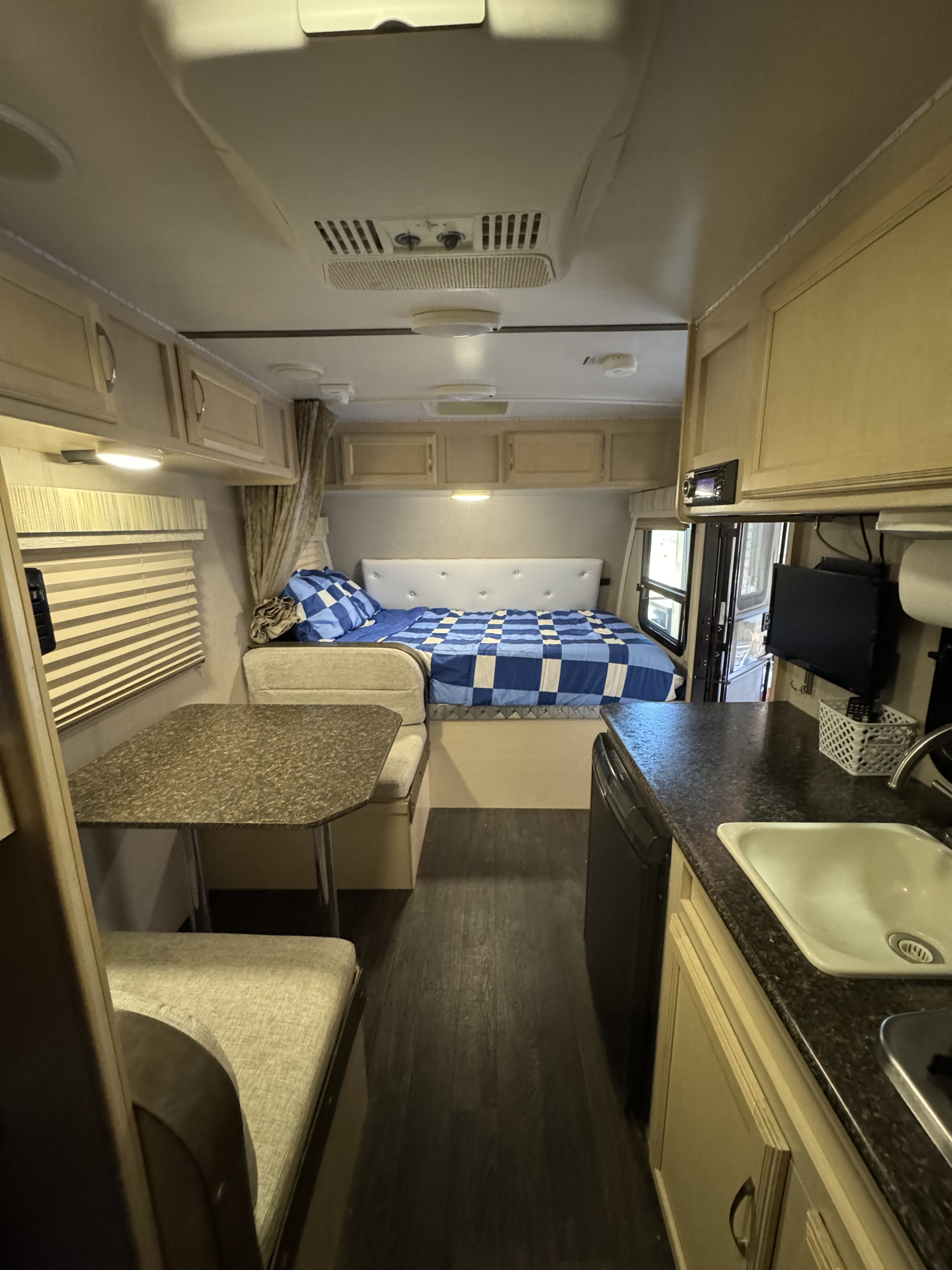 Cozy rv rental interior showing a comfortable bed, functional dinette, and compact kitchen area for your travel adventures.. Winnebago Micro Mini 1700BH 2019