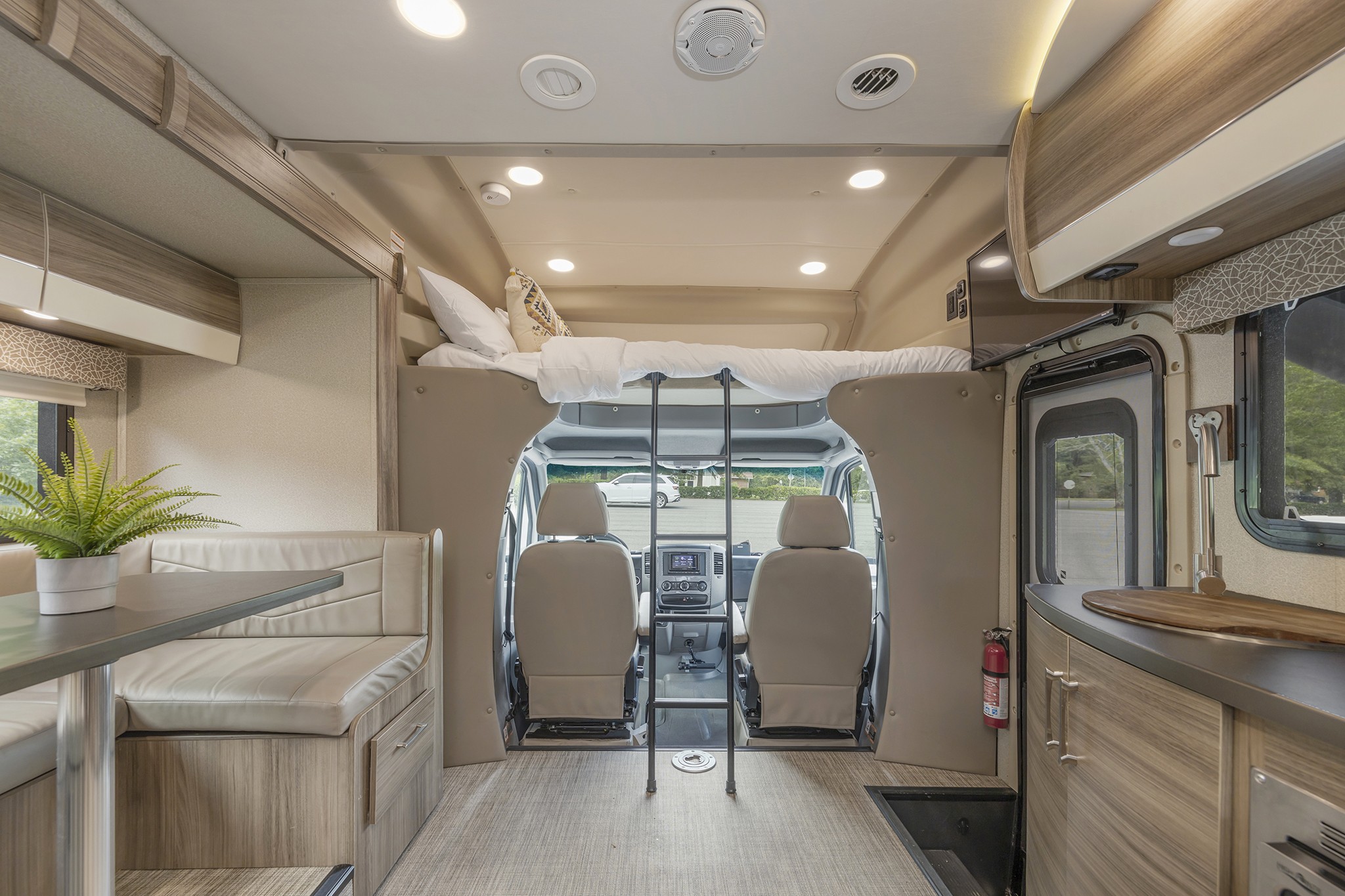 RV rental interior: Overhead bed with ladder, dinette, and modern kitchen setup.. Jayco Melbourne 2018