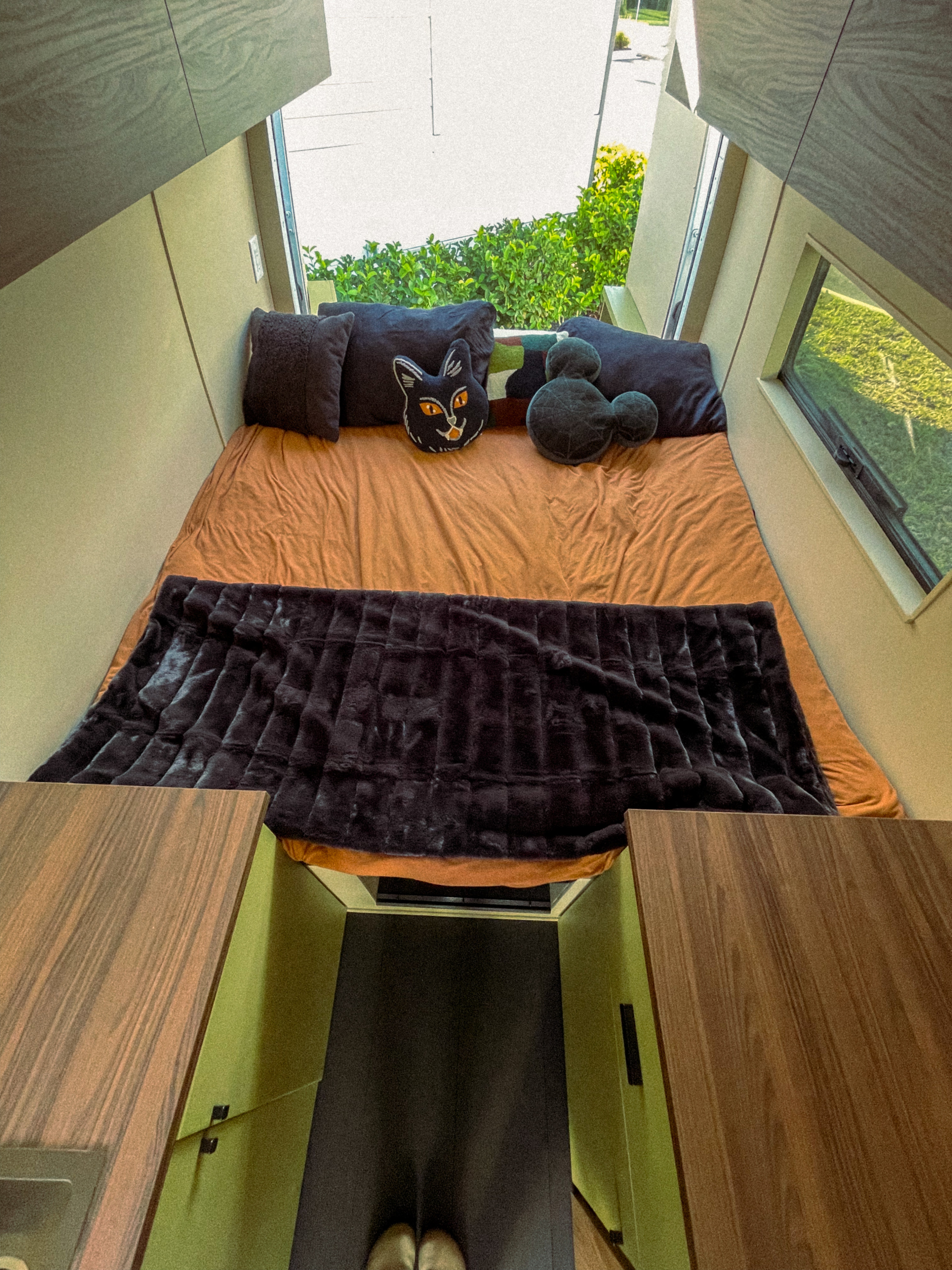 Experience a cozy rv rental! This modern sleeping nook features an orange bed, plush blanket, fun pillows, and scenic windows.. Mercedes-Benz Sprinter RV Motorhome Campervan 2018