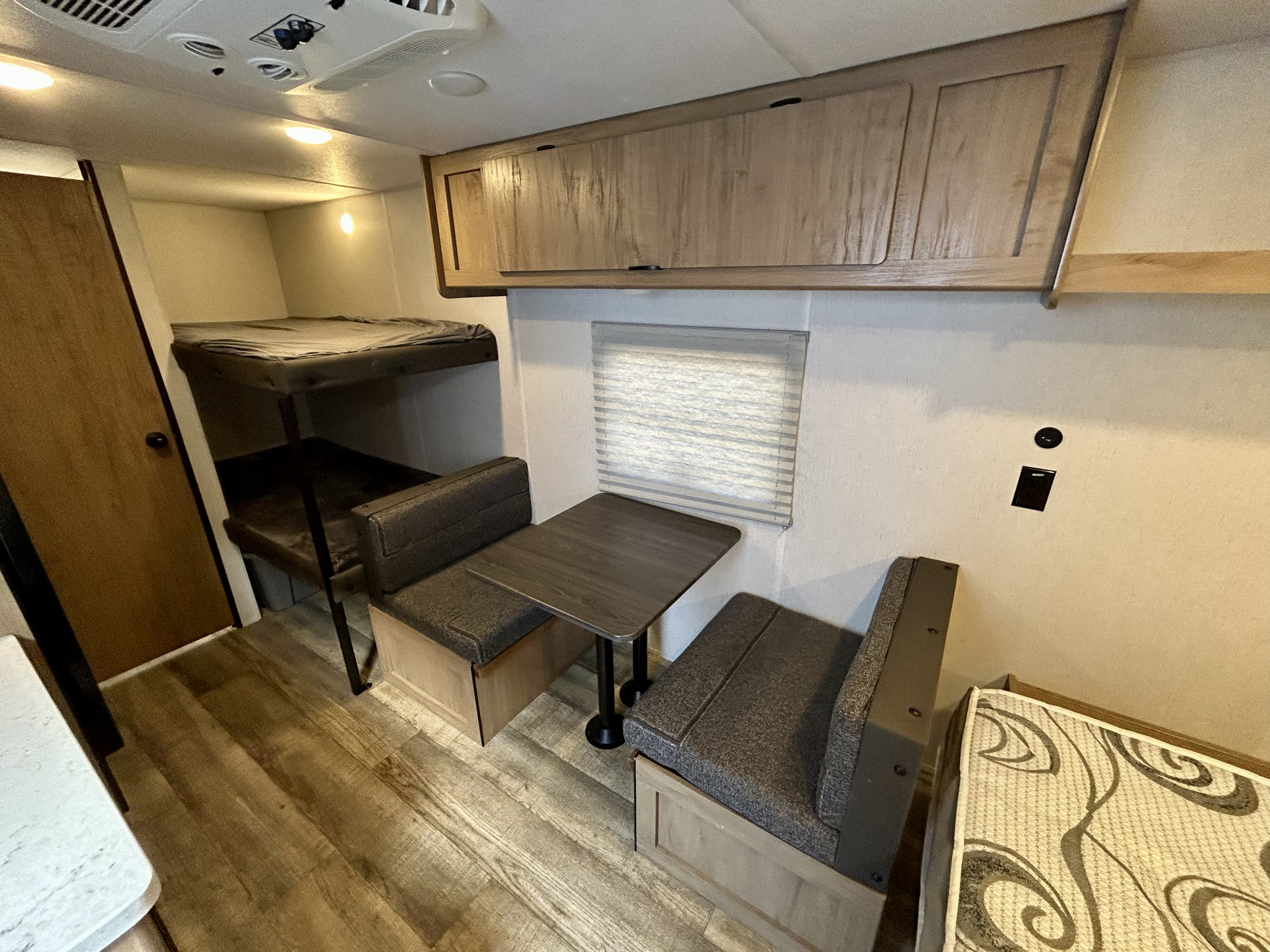 Inside this rv rental: bunk beds, a dinette with bench seating, and overhead cabinets offer functional space.. Forest River Cherokee Wolf Den 2024
