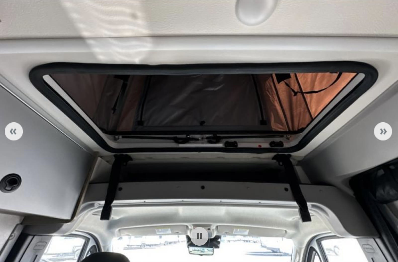 View inside an RV rental showing an open pop-top roof, perfect for extra headroom or sleeping space on your trip.. Winnebago Solis 2025