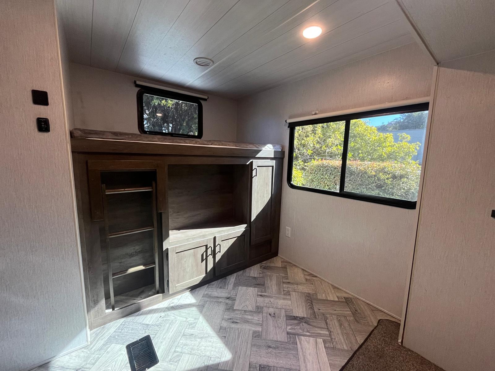 RV rental interior: bunk beds, built-in storage, and bright windows with stylish wood-look flooring.. Forest River EVO T3250 2022