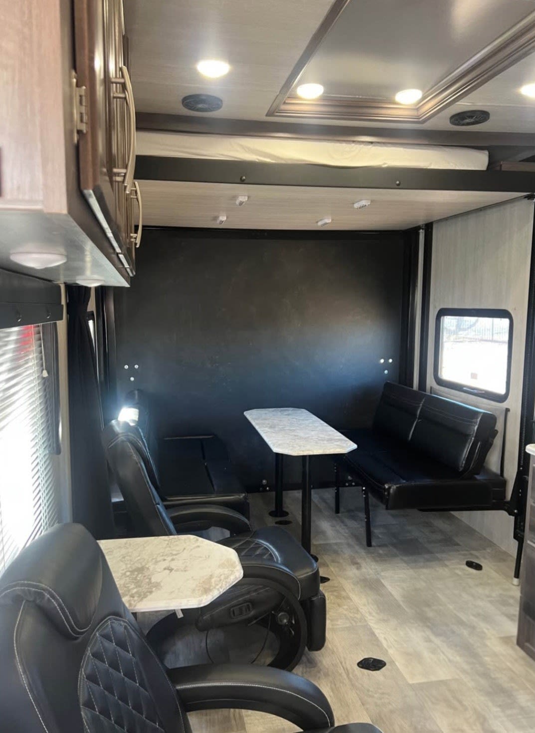 Versatile RV rental interior: recliners, dining table, bench seating, & drop-down bed. Great for a toy hauler adventure.. Genesis Supreme Rv Other 2022