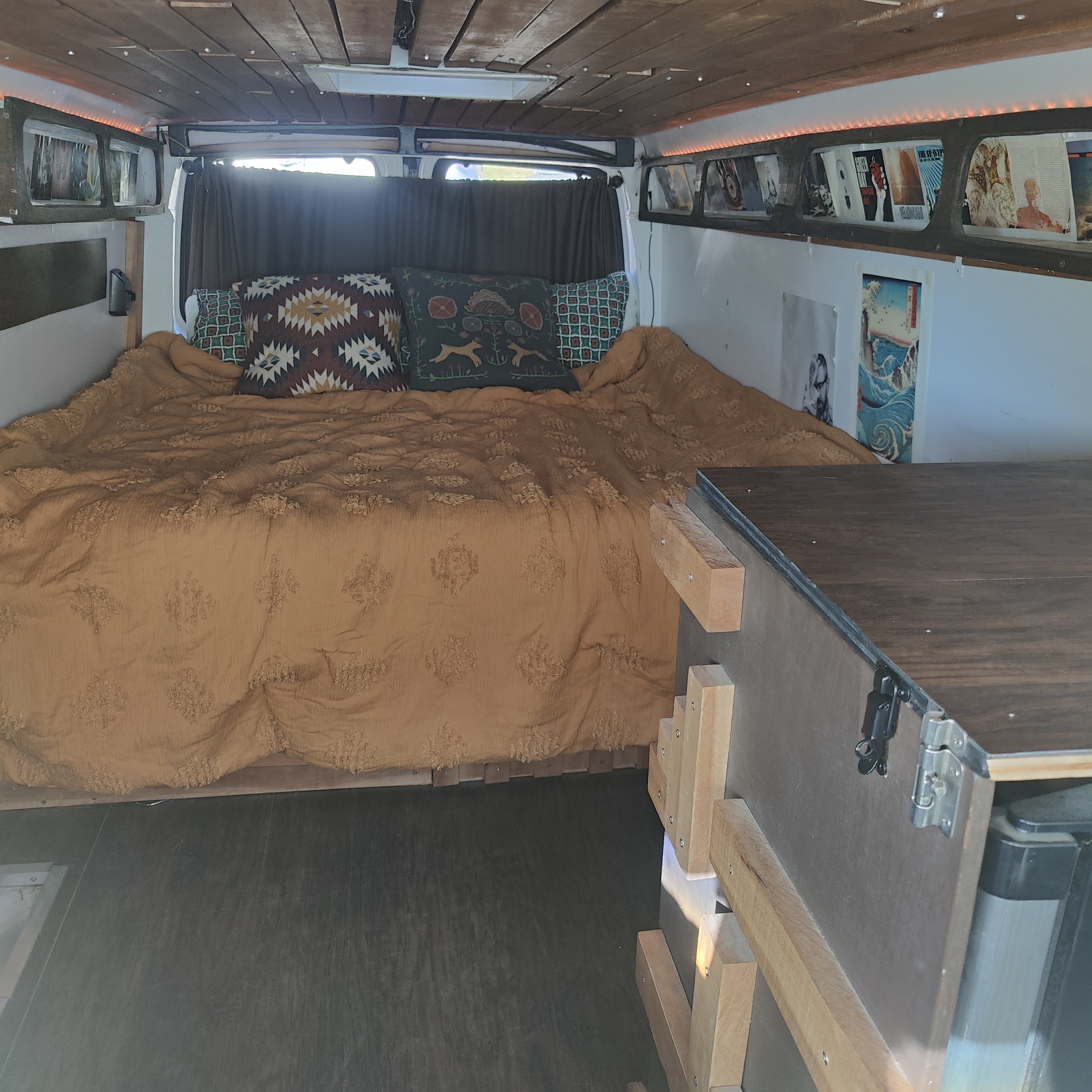 A welcoming RV rental interior features a comfortable bed with patterned pillows, wooden ceiling, and illuminated storage shelves.. Chevrolet CHEVY EXPRESS 1500 2004