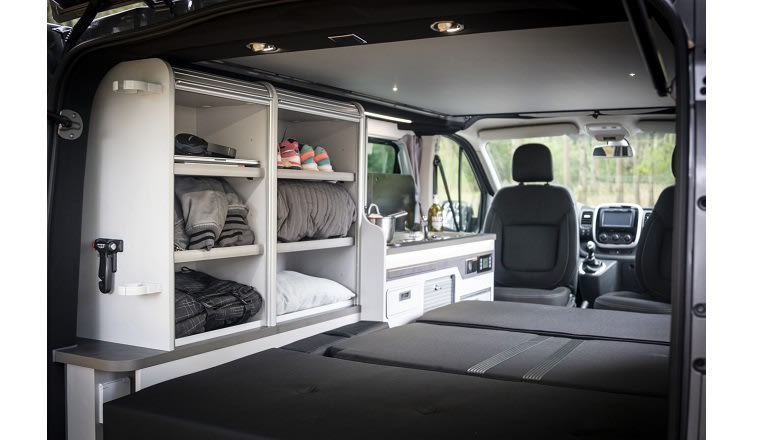 Compact rv rental interior with smart storage, a kitchenette, and a bed, perfect for your next adventure.. Pilote CV500 2026