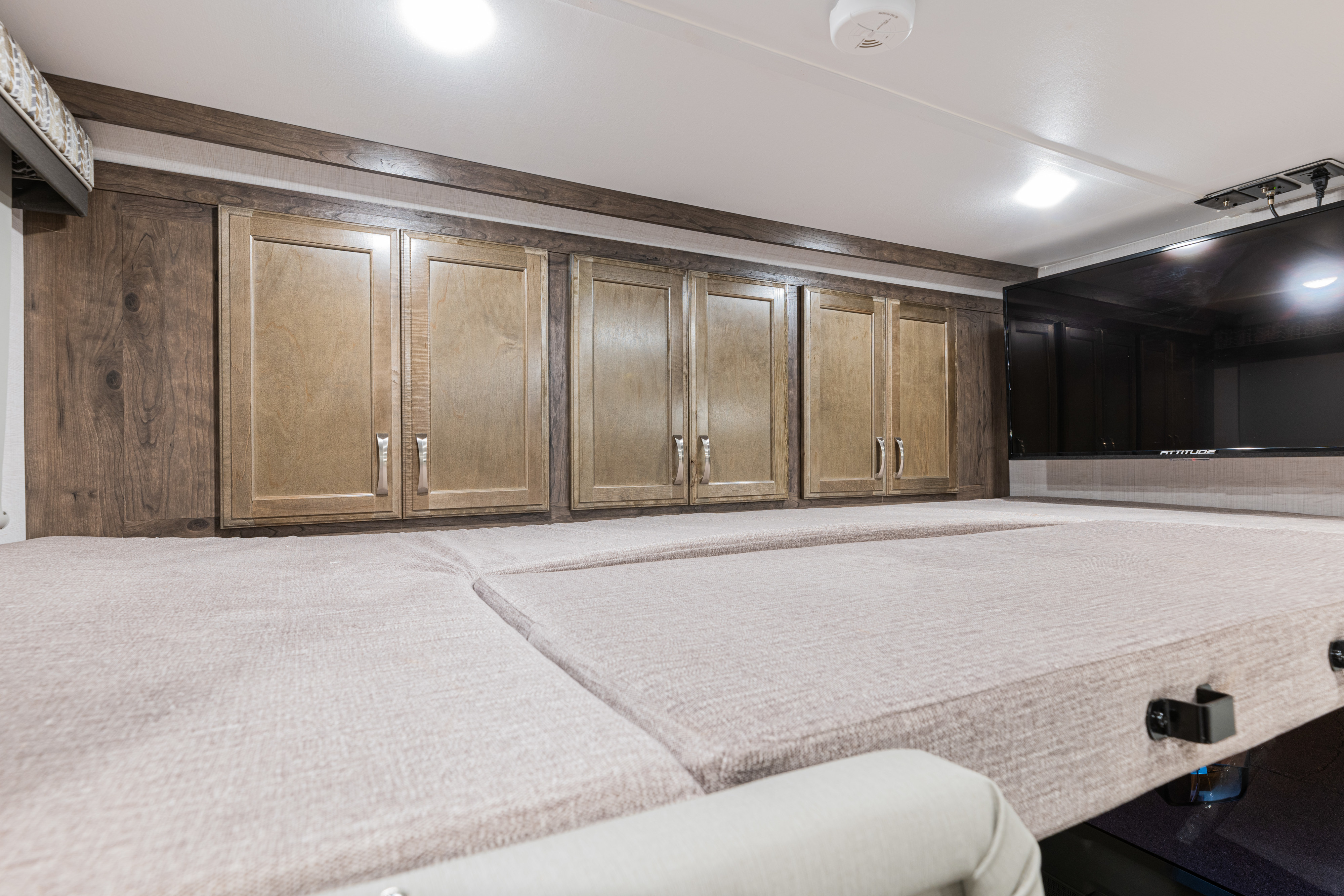 RV rental interior featuring a comfortable bunk bed area with ample wooden storage cabinets and a TV for entertainment.. Gulf Stream Yellowstone 2023