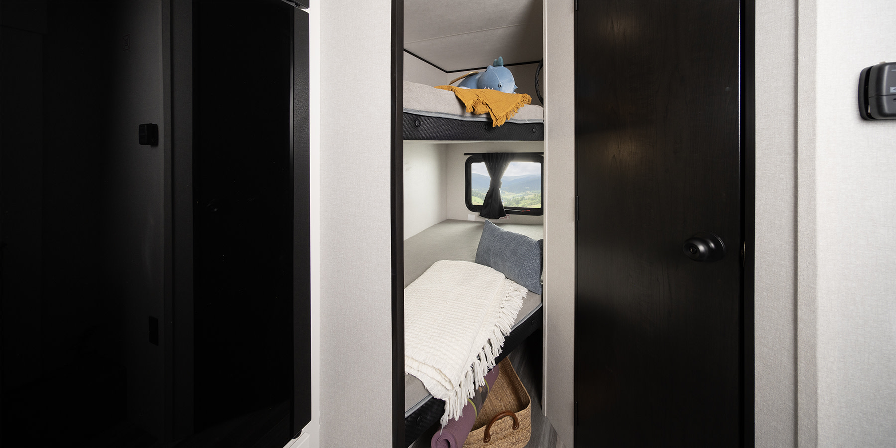 Cozy RV rental bunk beds, perfect for family travel. Features a window with mountain views, pillows, and blankets.. Jayco Jay Flight SLX 2025