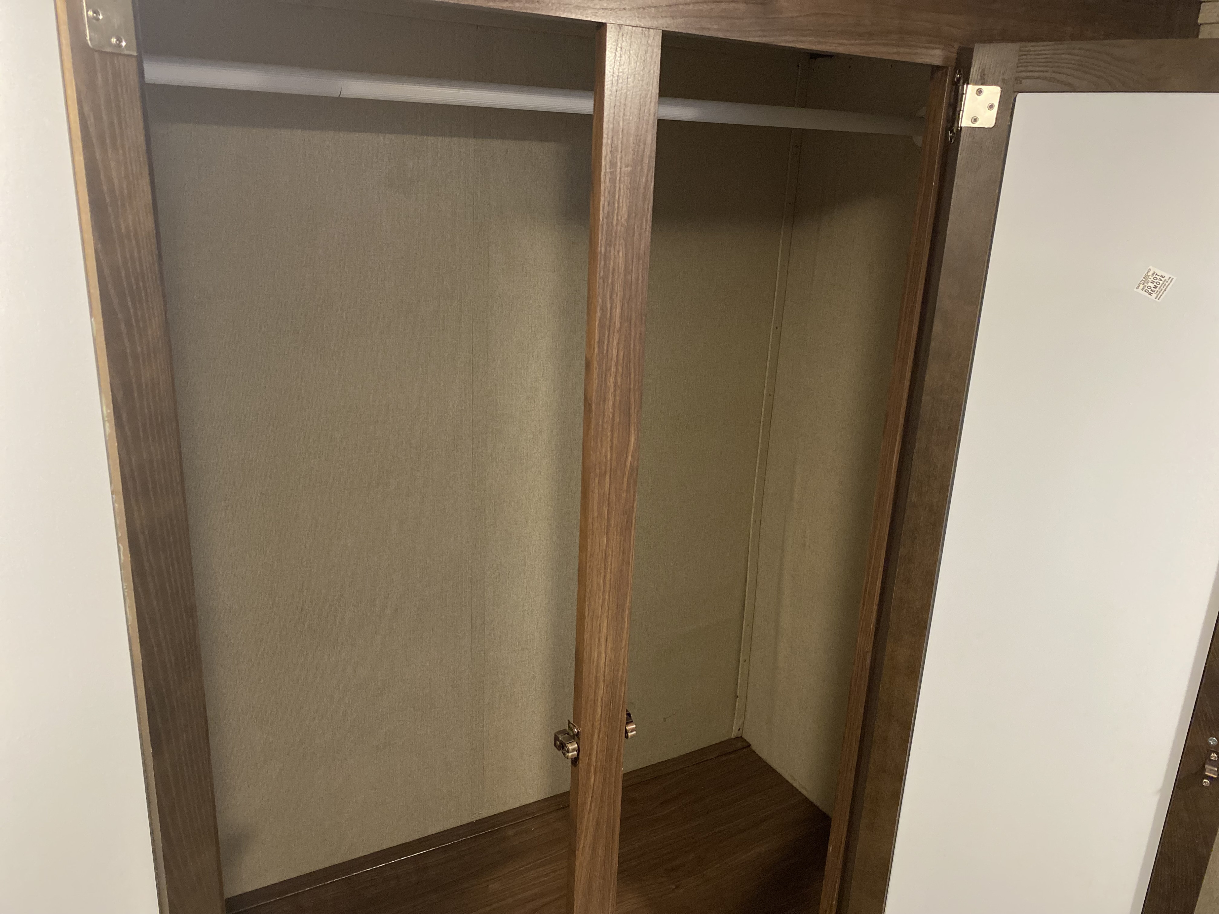 Inside an RV rental: an empty, compact closet with a hanging rod, offering convenient wardrobe storage.. Coleman 2305QB 2017