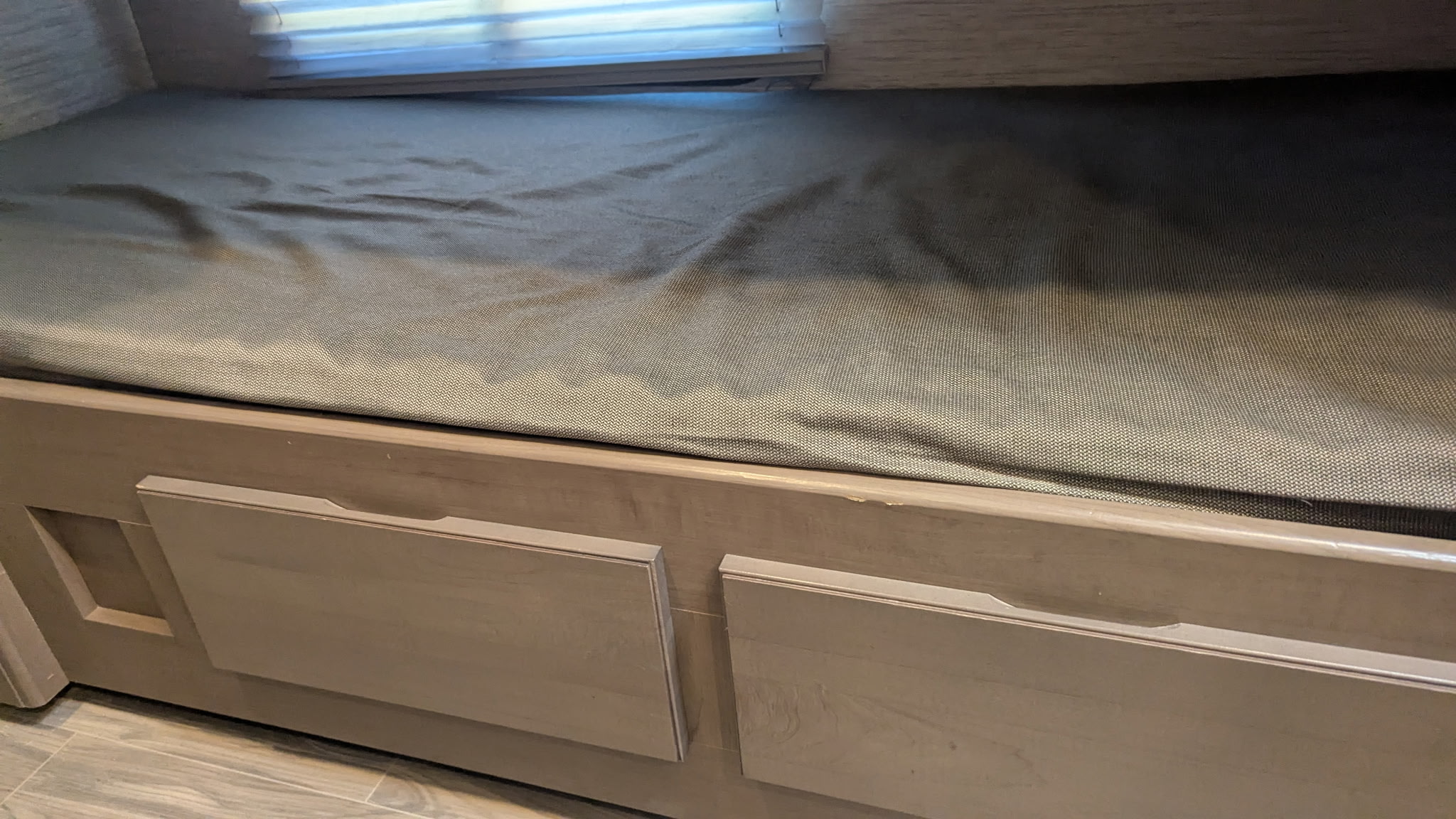 Cozy RV rental bunk bed featuring a gray mattress and practical under-bed storage drawers. Ideal for compact living.. Thor Four Winds 2022