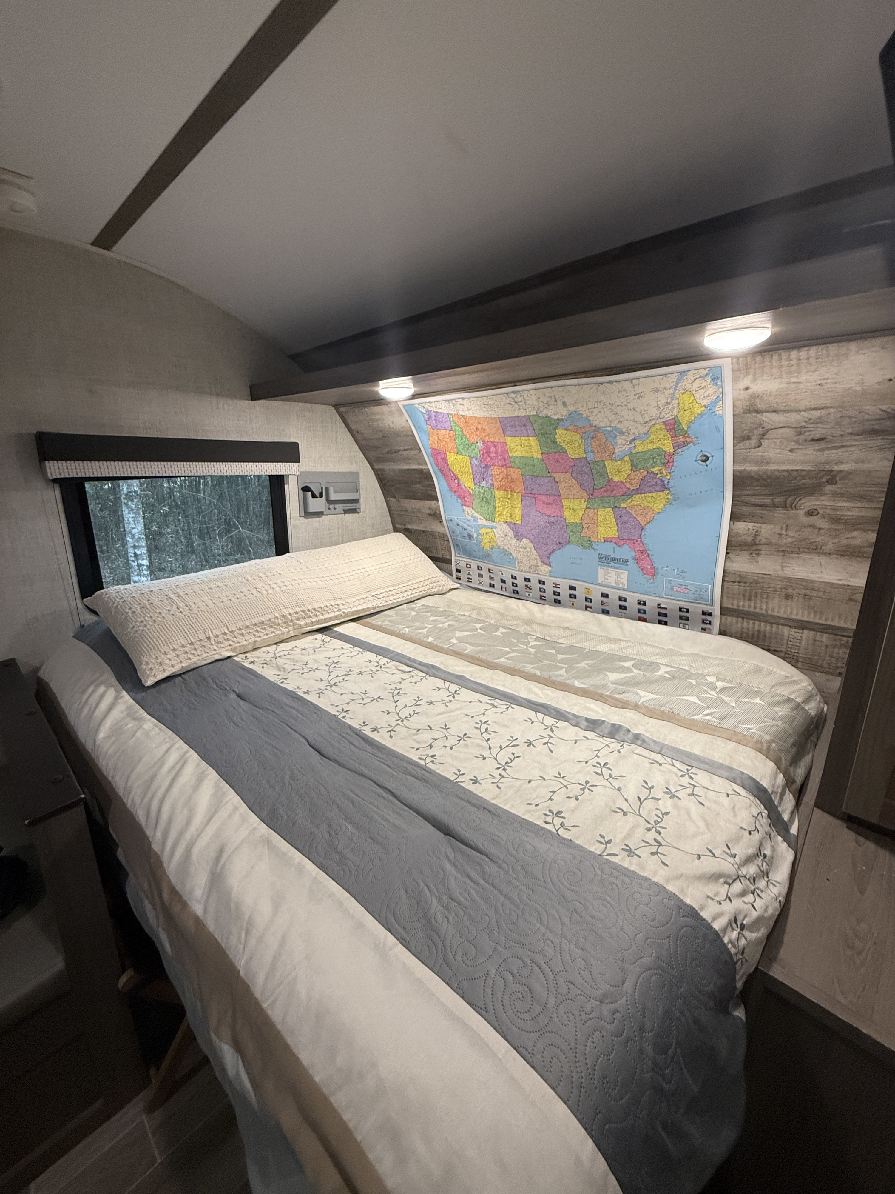 Cozy RV rental bedroom with a comfy bed, a US map for tracking travels, and a scenic window view.. Gulf Stream Enlighten 2021