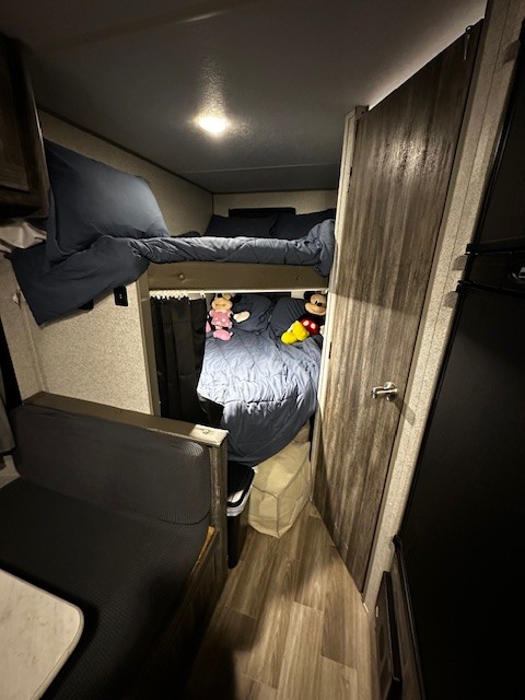 Cozy RV rental interior showcasing bunk beds with blue bedding, a dinette, and fun Mickey & Minnie plushies.. Forest River Salem FSX PLATINUM 2020