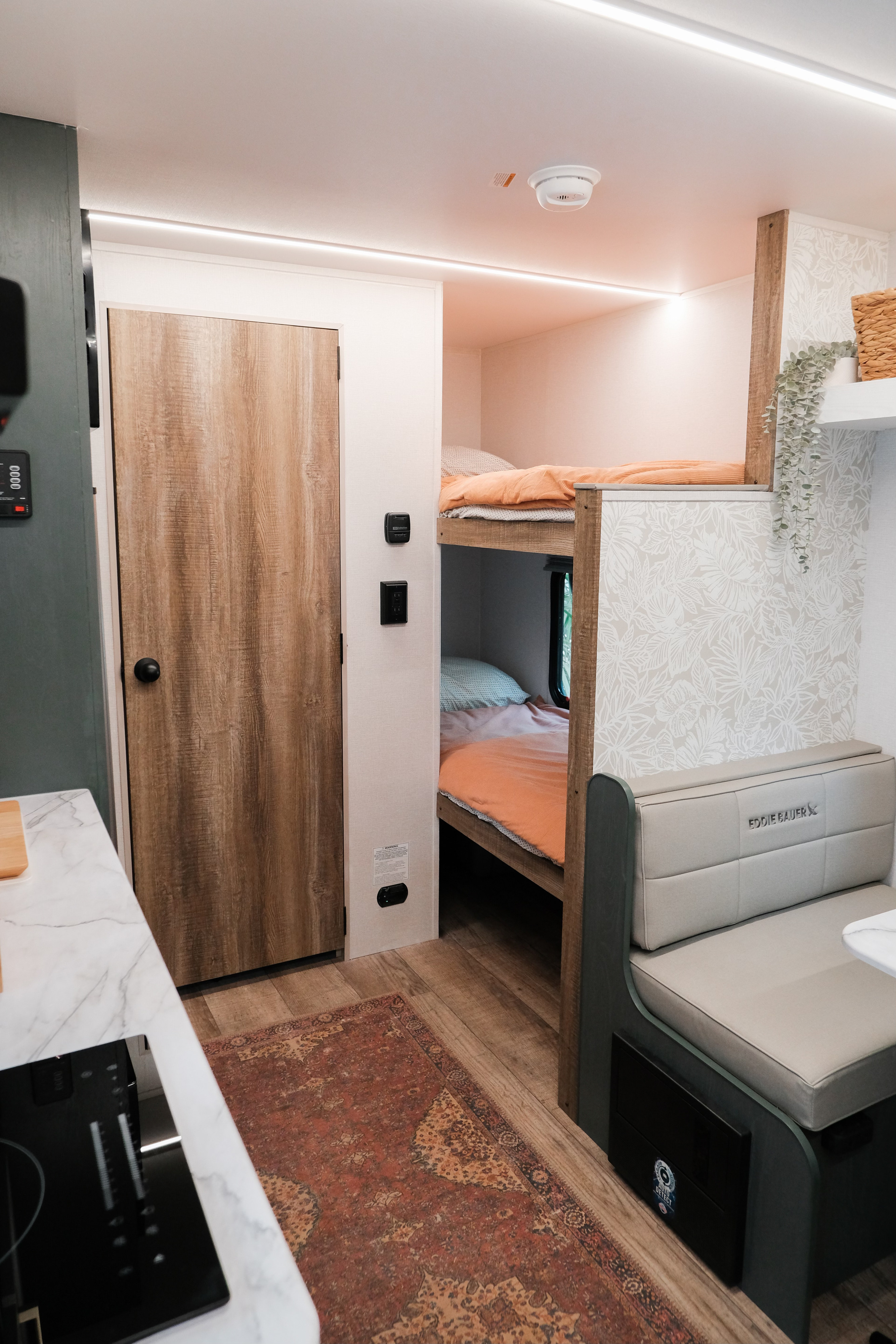 Modern RV rental interior: bunk beds, dinette, light wood tones & fresh decor for a comfy stay.. Heartland RVs Eddie Bauer 2025