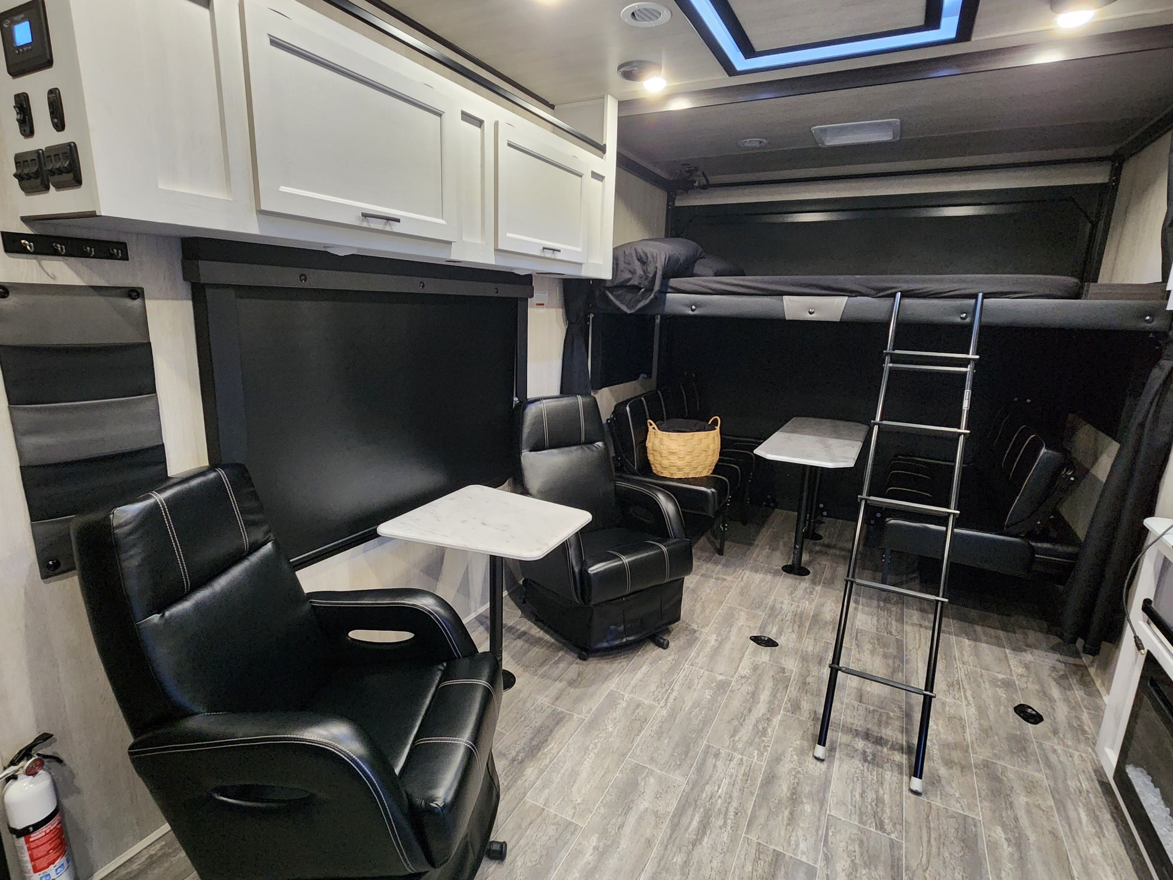 Interior view of an RV rental: two recliners, a ladder to bunk beds, and a dinette area on tile flooring.. Genesis Supreme Rv Genesis Supreme 2026