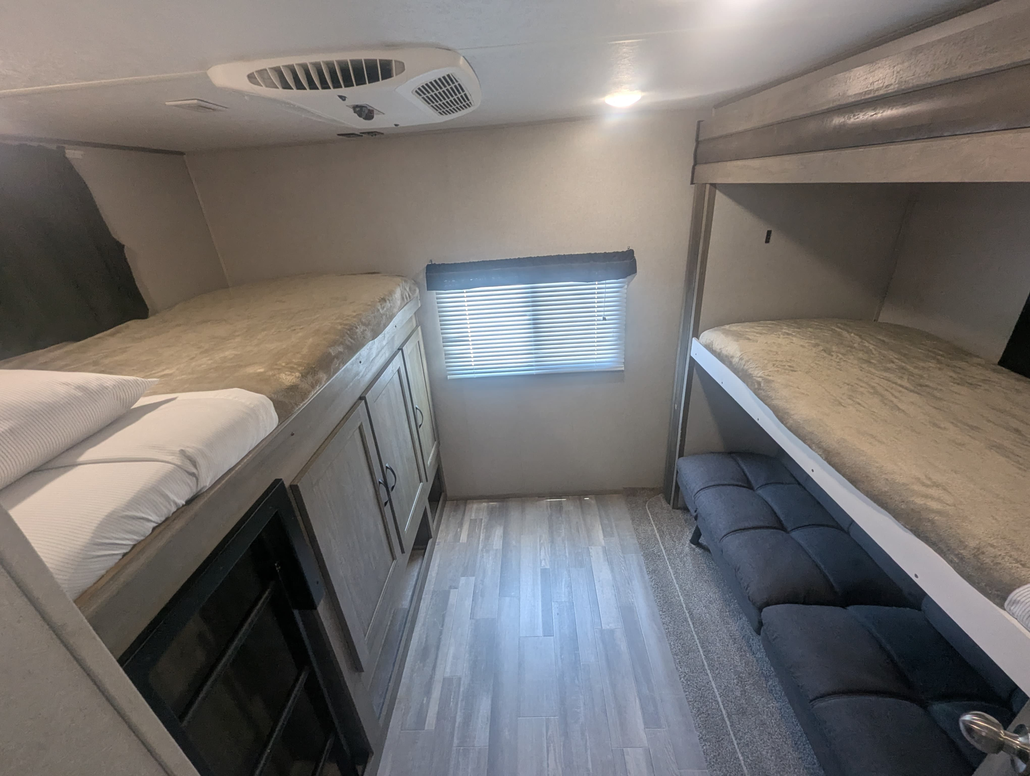 Explore this RV rental's sleeping area with dual bunk beds, ceiling AC, window, and storage for comfortable trips.. Forest River Vibe 2020