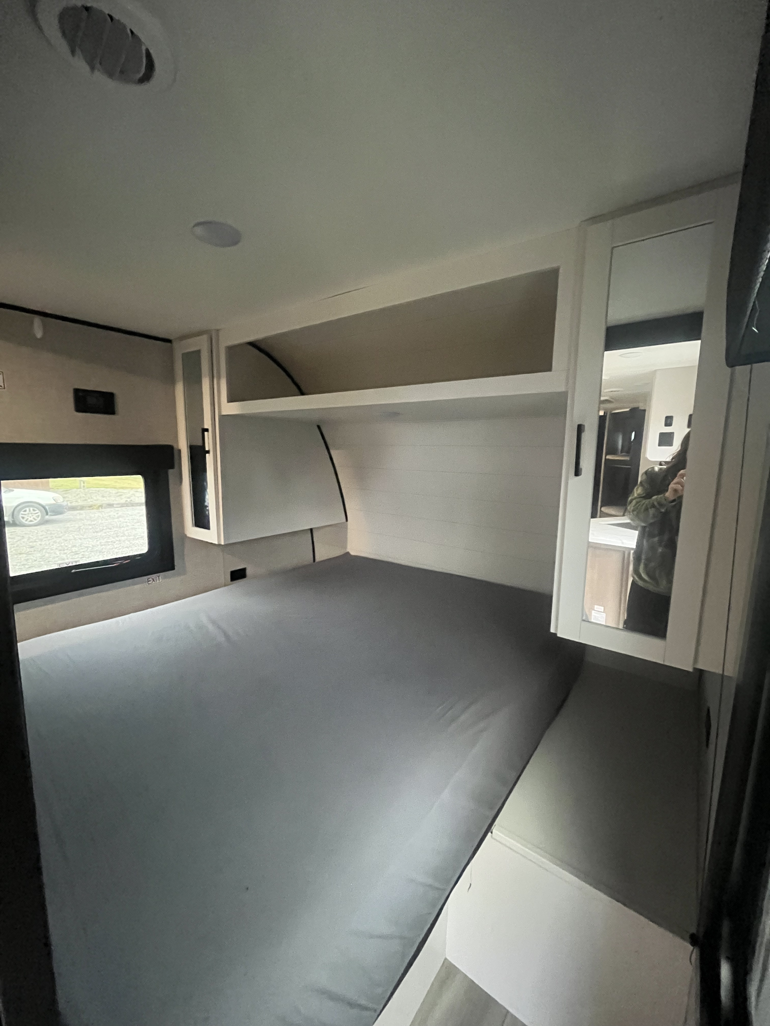Modern RV rental bedroom features a large bed, built-in storage, and a mirrored closet, ready for your next adventure.. Highland Ridge RV Open Range 2025