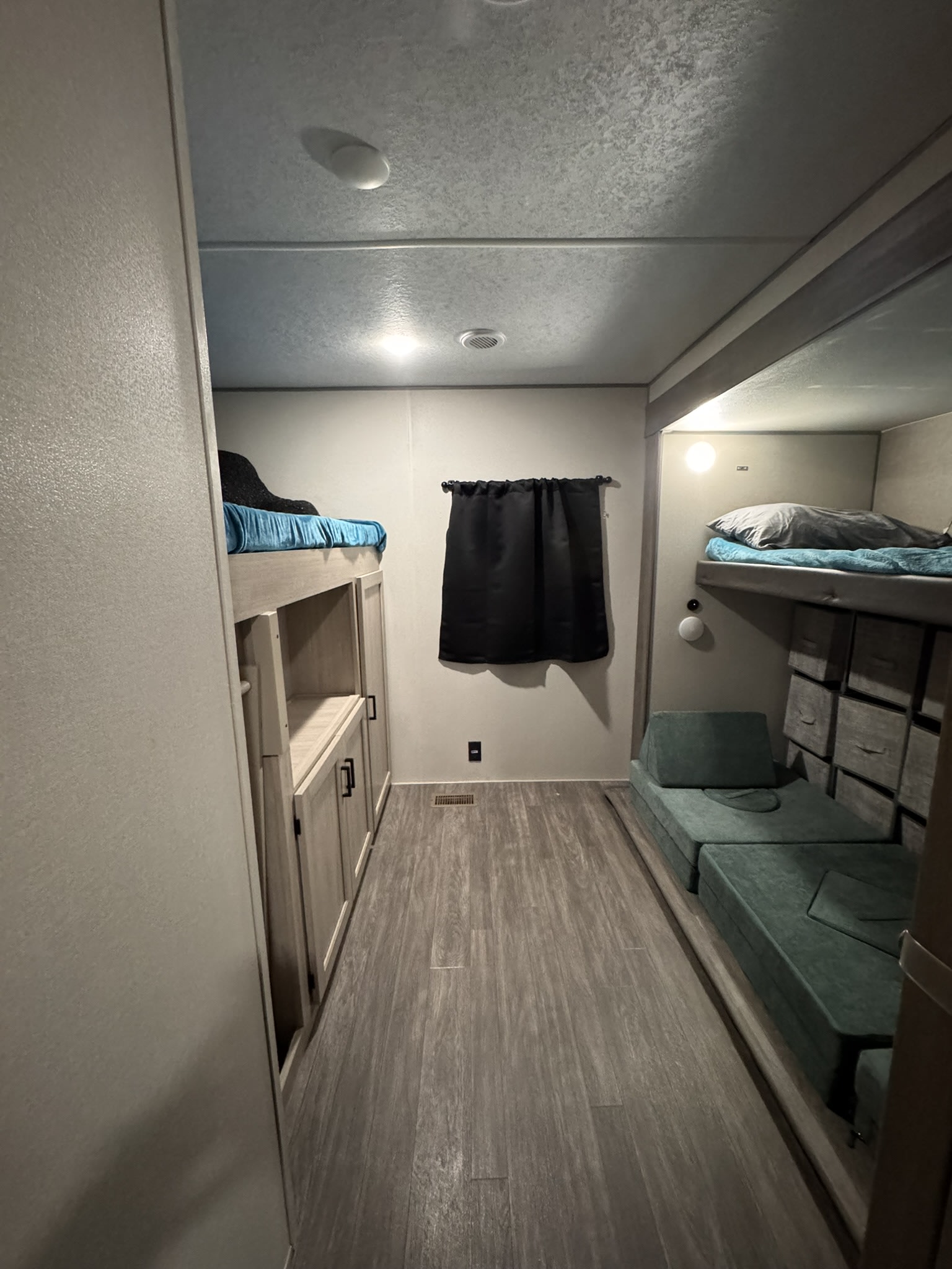 View inside an RV rental's bunk room, showing beds, modular green seating, and built-in storage.. Forest River Aurora Aurora 2024