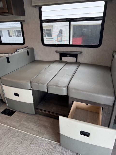 RV rental interior with a versatile dinette that converts to a bed, featuring an open storage drawer.. Forest River Coachmen Mirada 2023