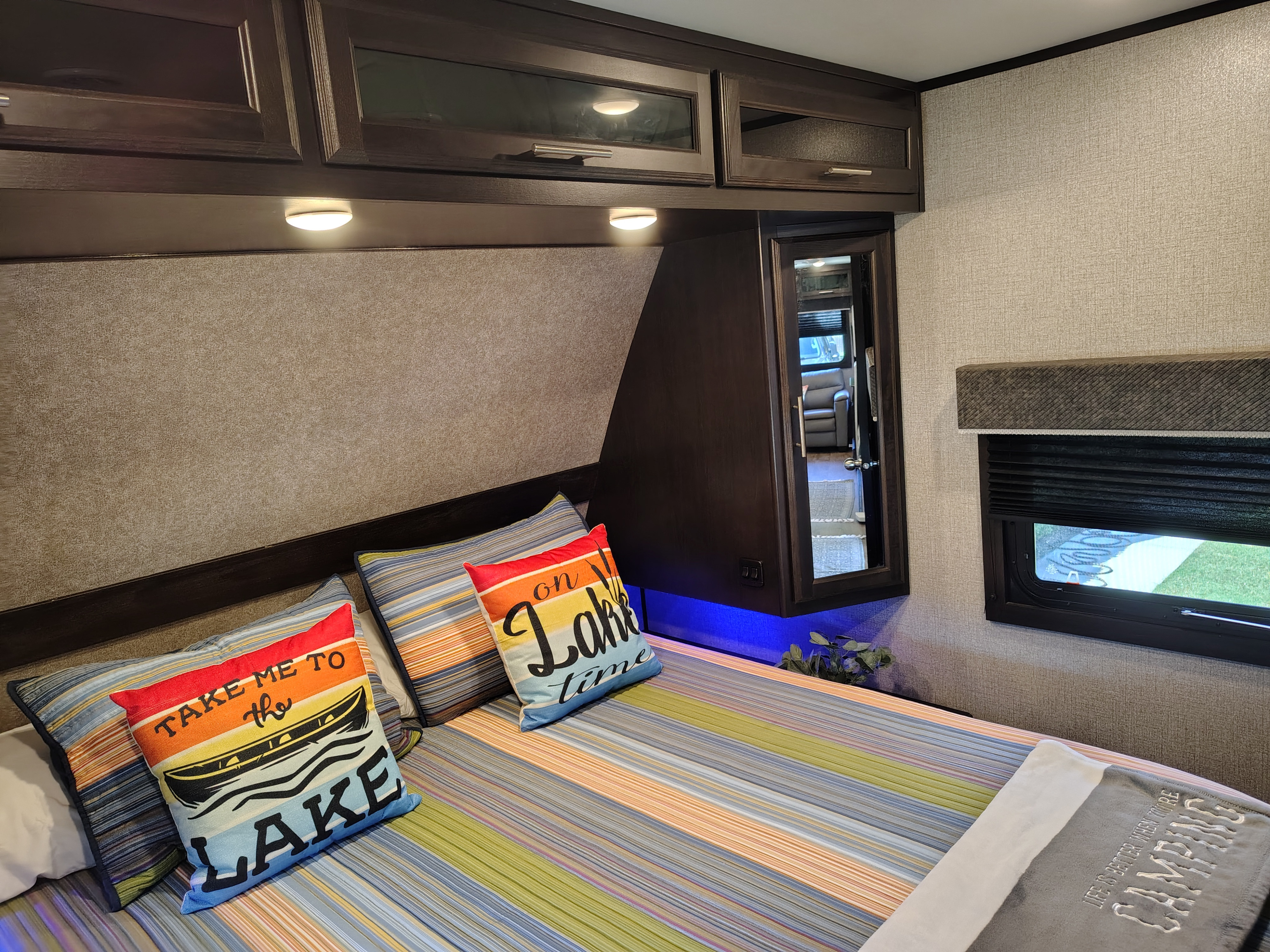 Cozy RV rental bedroom with lake-themed decor, modern cabinetry, and an inviting bed for a comfortable stay.. Jayco Eagle HT 2021