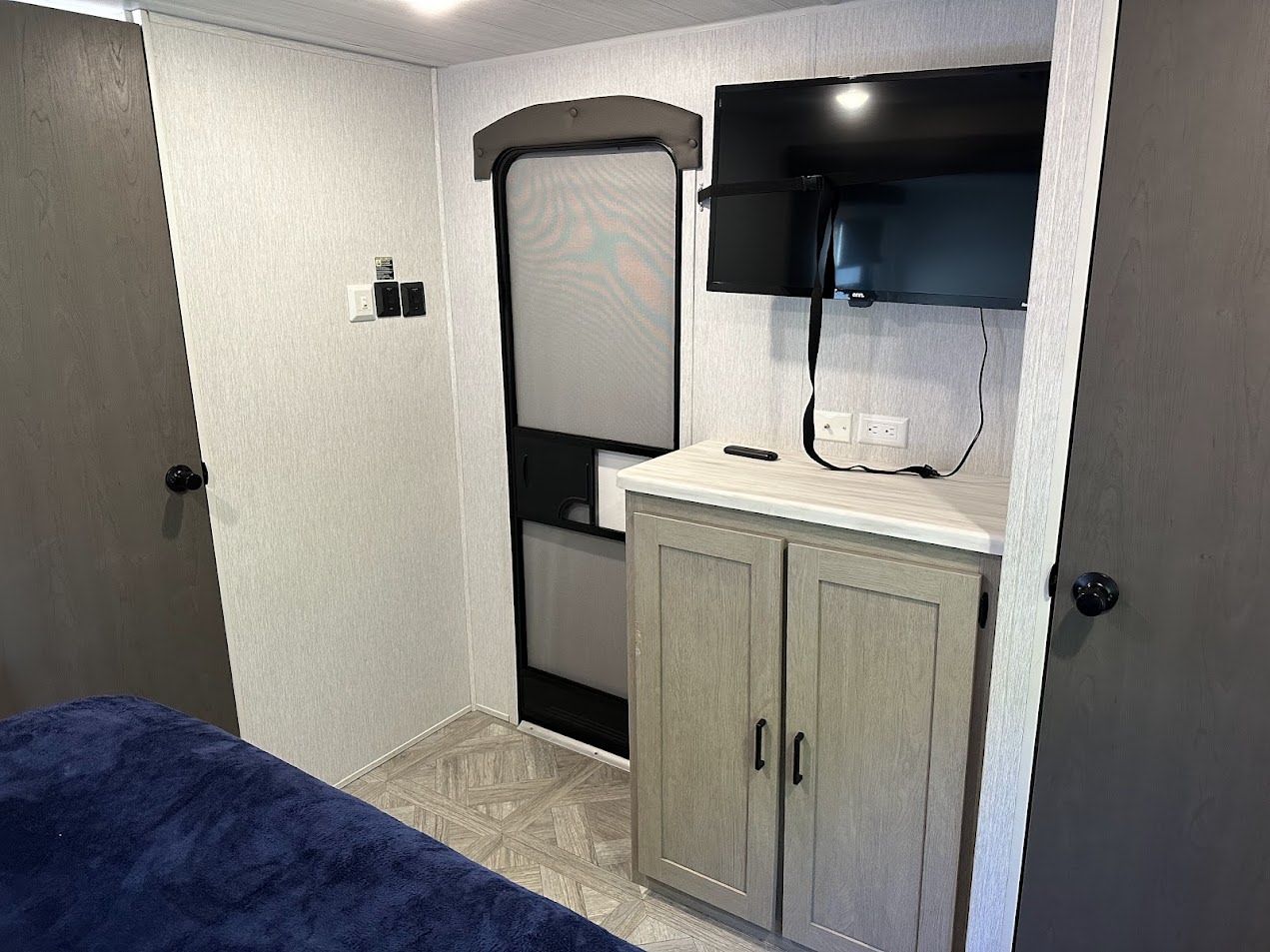 Comfortable RV rental interior showing a bed, screen door, TV, and storage cabinet, perfect for your next adventure.. Salem 36VBDS 2023